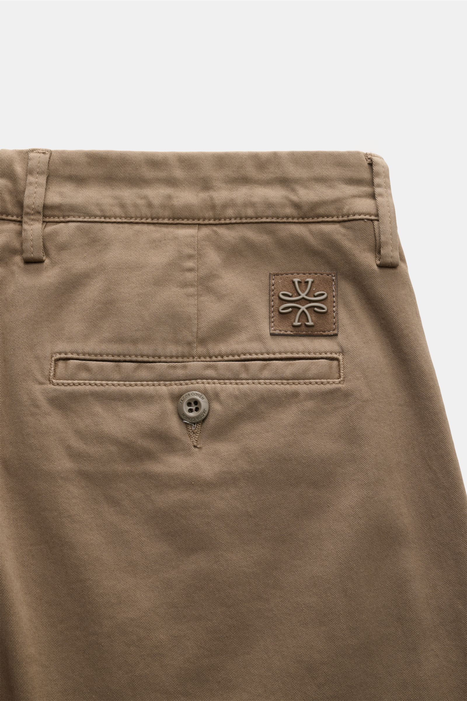 Jacob Cohen Chino 'Bobby' graubraun shown from a close-up rear angle, highlighting the slim fit, tonal veloursleder patch, buttoned back pocket, and soft, elastic cotton fabric. Setzen Sie auf modernen Luxus im Alltag: Die schmal geschnittene Chino 'Bobby