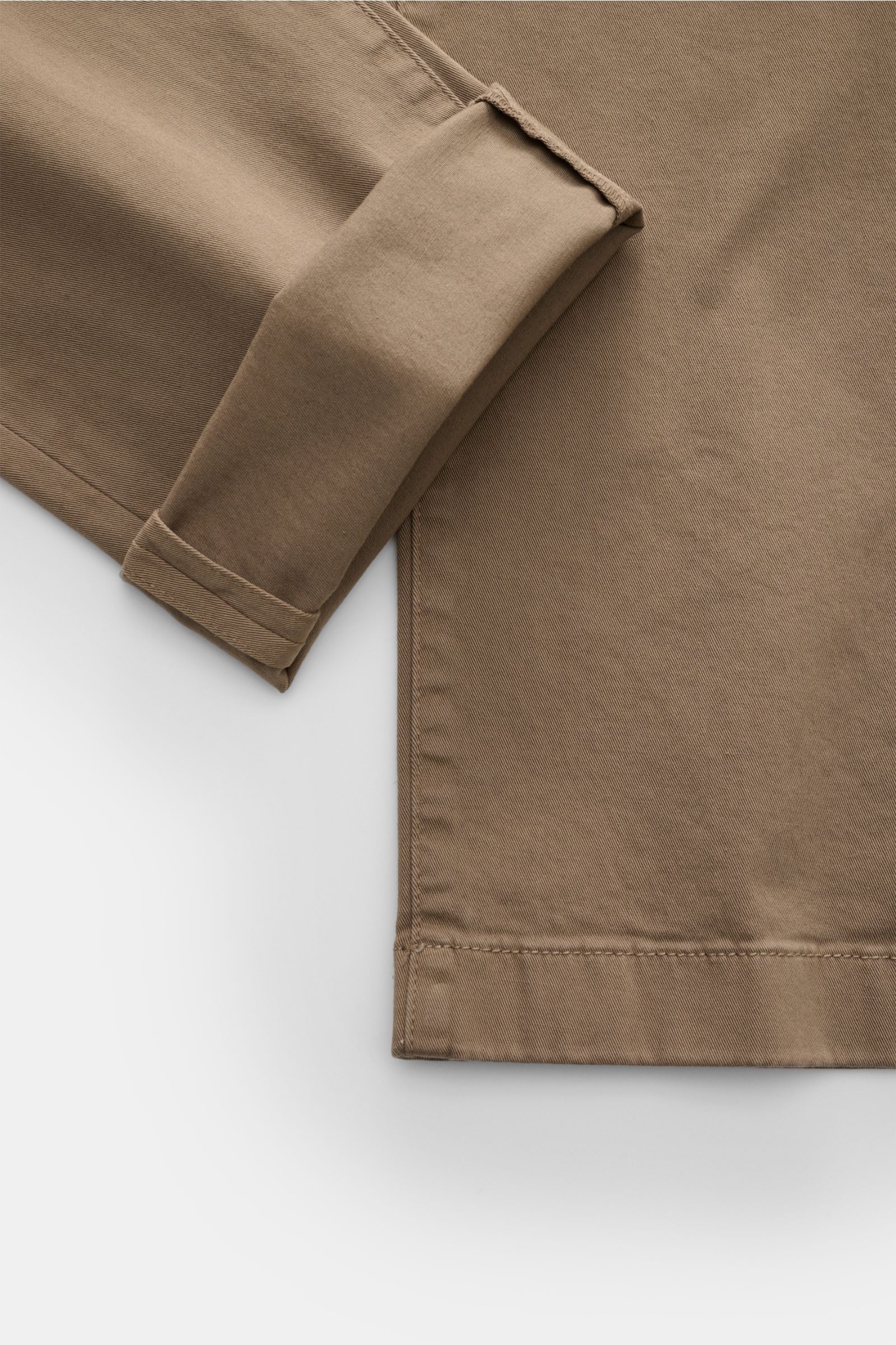 Jacob Cohen Chino 'Bobby' graubraun shown from a close-up side angle, highlighting the folded cuff and fine stitching on slim-fit elastic cotton fabric. Setzen Sie auf modernen Luxus im Alltag: Die schmal geschnittene Chino 'Bobby' von JACOB COHEN überzeu
