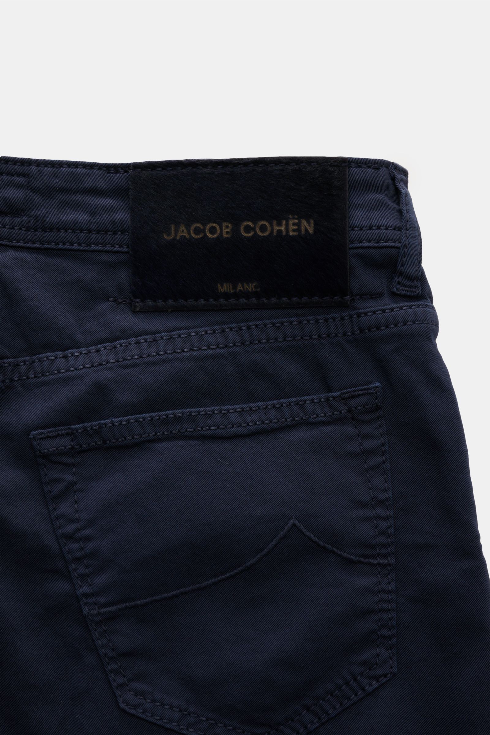 Close-up rear view of Jacob Cohen Baumwollhose 'Bard' navy cotton pants showing the back pocket and signature pony hair leather patch.

Description: Setzen Sie auf modernen Luxus im Alltag: Die Five-Pocket-Hose 'Bard' von JACOB COHEN kombiniert hochwer