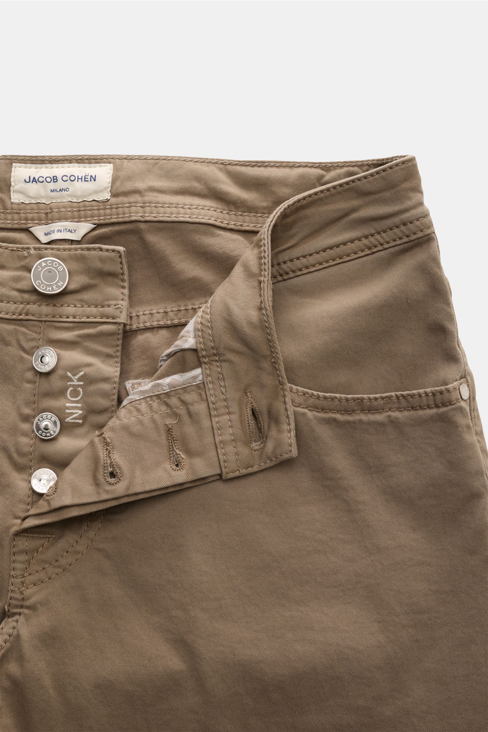 Jacob Cohen Baumwollhose 'Nick' graubraun, Five-Pocket-Stil, Slim Fit, elastisch, Button Fly mit offenem Bund aus schräger Draufsicht, Lederpatch in Ponyfell-Optik.