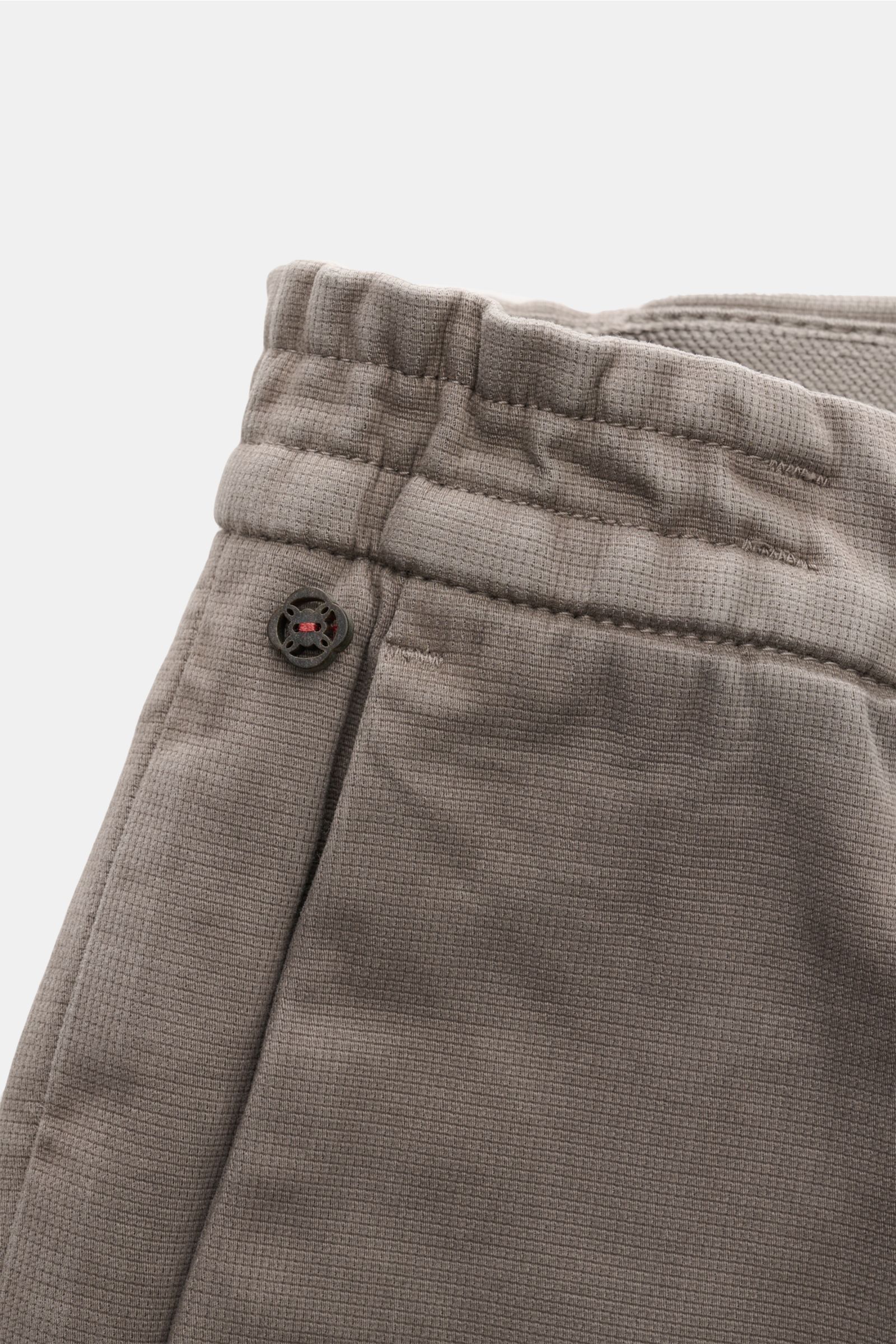 Alt tag (125 characters max):
Close-up front view of GTA Trousers 'Dennis' grey-brown waistband with elastic, button, and textured cotton-lyocell fabric.

Detailed description:
With the cropped, tapered trousers 'Dennis', GTA presents an essential that