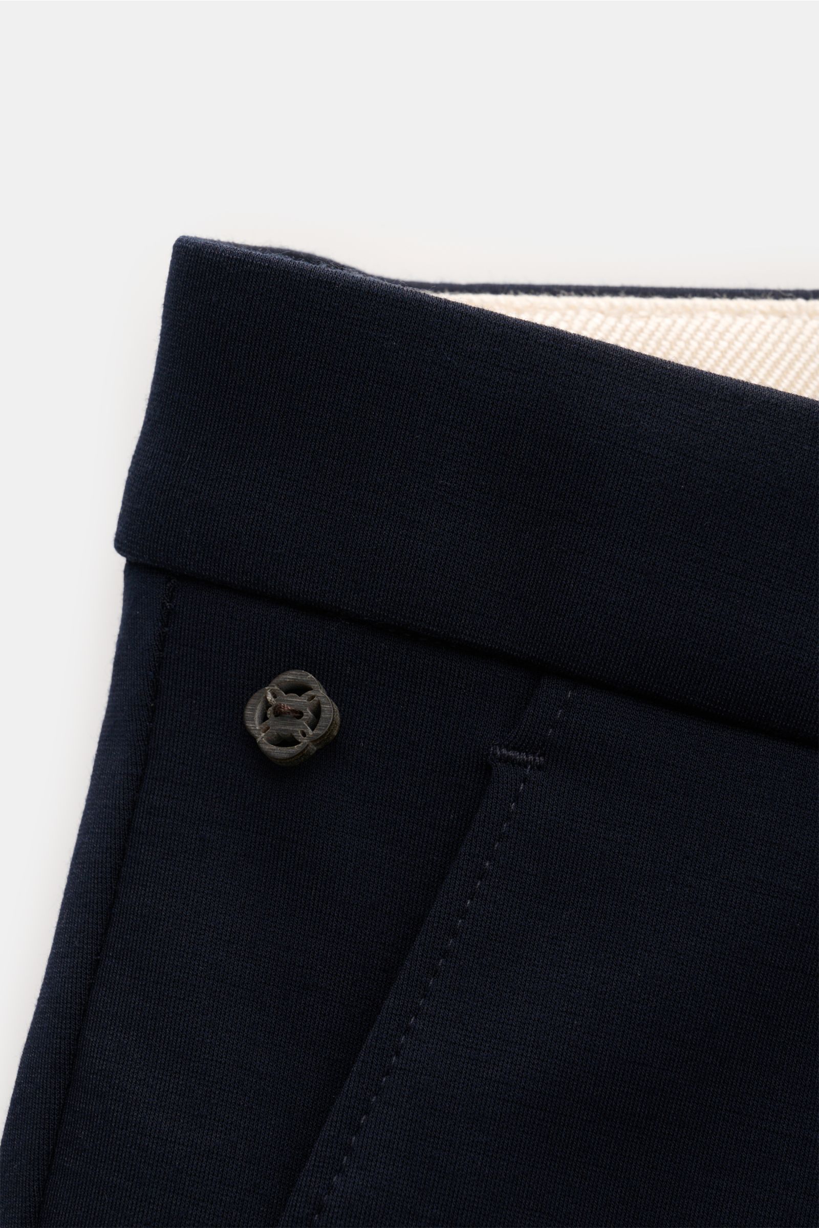 Close-up top-down view of the waistband of GTA Trousers 'Federico' navy, showing the slightly elasticated navy fabric, button, and folded waistband. For stylish office looks: The trousers 'Federico' by GTA combine maximum comfort with timeless elegance to