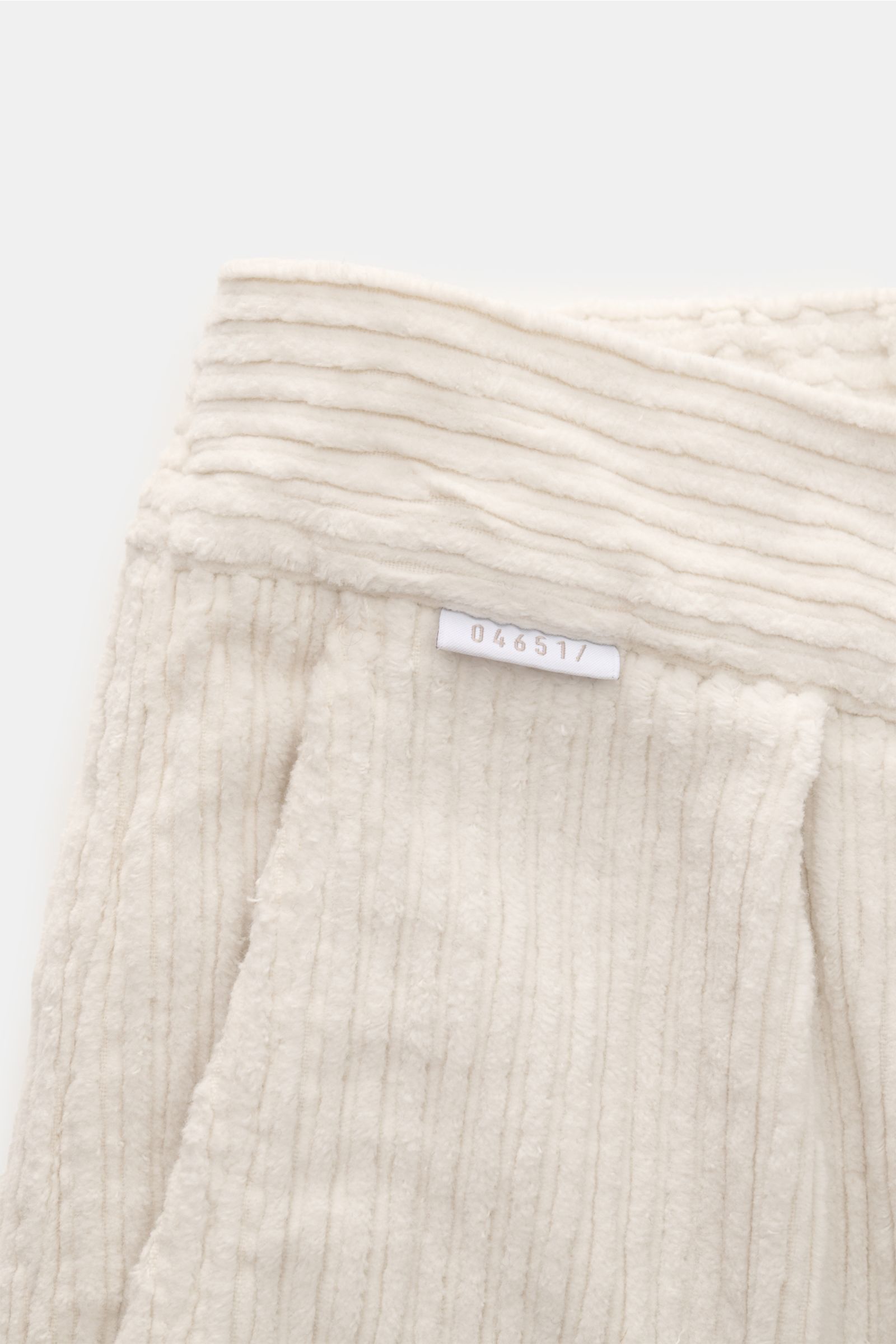 Close-up top view of the offwhite 04651/ A trip in a bag Cordhose, a stylish allrounder corduroy pant with elastic cotton, soft touch, tapered fit, regular thigh width, ankle length, narrow leg, zipper and button, partially elastic waistband, double pleat
