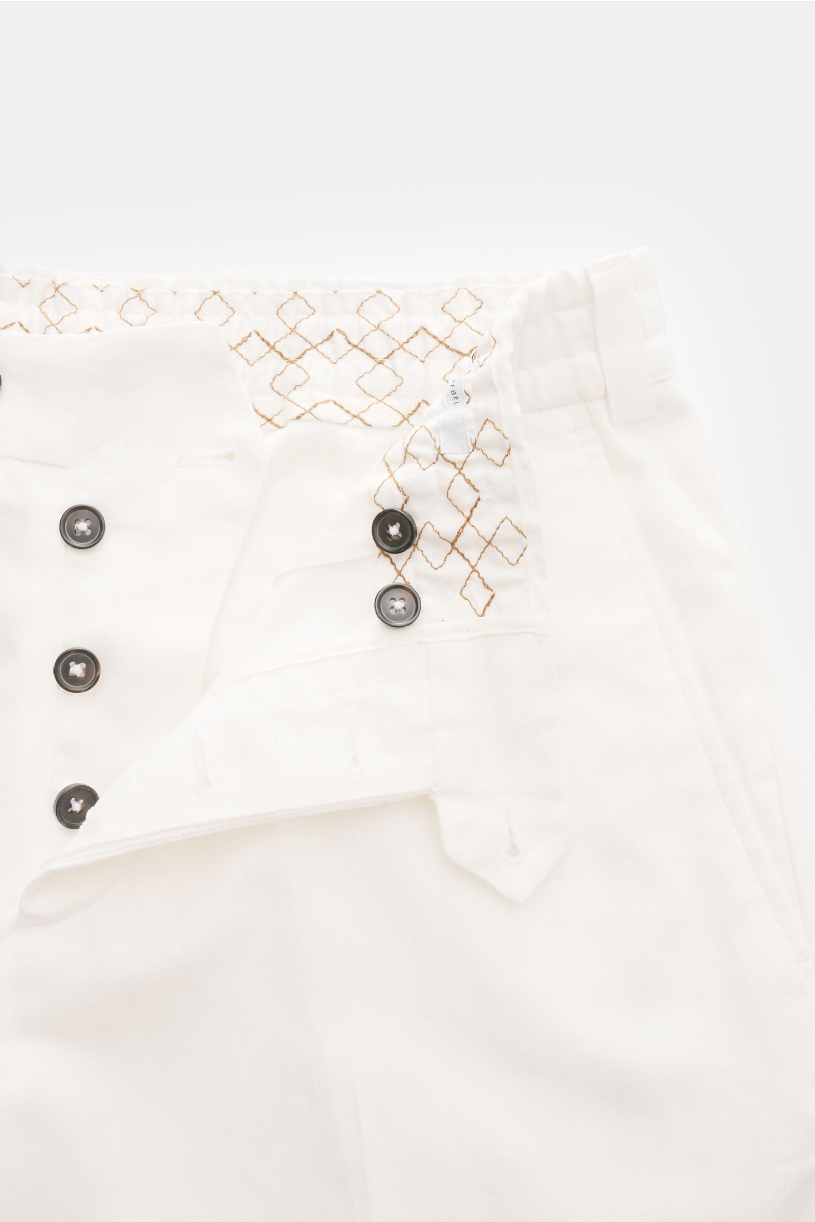 Off-white PT Torino Jogger pants 'The Rebel' shown from top close-up with open button fly, elasticated waistband with brown diamond pattern, French and back button flap pockets, regular fit, tapered and cropped cut, cotton-linen blend, soft feel, fixed he