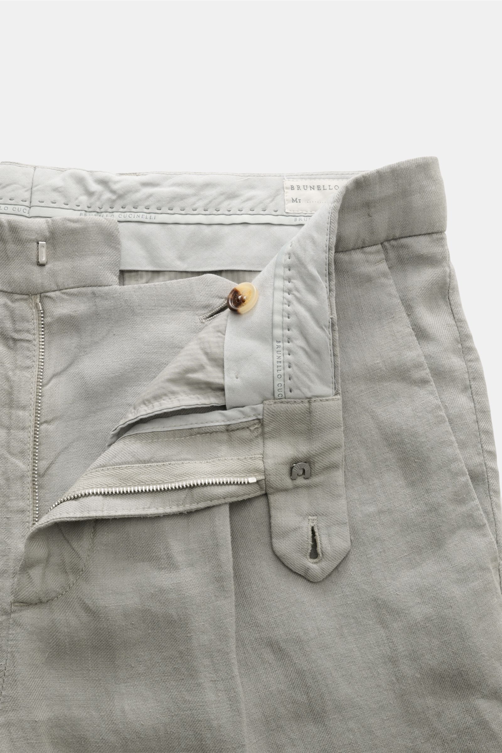 Close-up front view of Brunello Cucinelli Leinenhose salbei, a luxury Italian linen pant with zipper, button, soft texture, and classic pleat. Ikonisches Essential in italienischer Luxusausführung: Die edle Leinenhose mit klassischer Bundfalte von BRUNELL