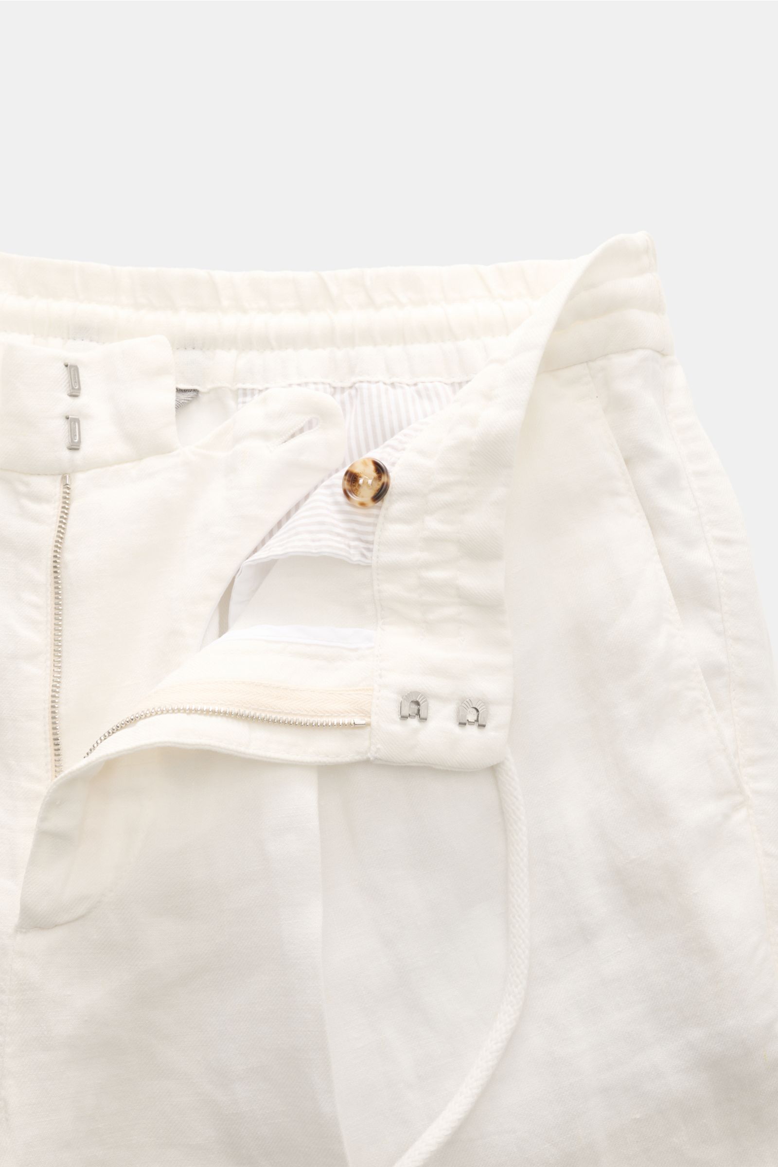 Close-up front view of Brunello Cucinelli Leinen-Jogpants offwhite showing elastic waistband with drawstring, zipper, button, and hook closure details.

Description: Stil trifft Tragekomfort: Die Jogpants aus reinem Leinen von BRUNELLO CUCINELLI ist ei