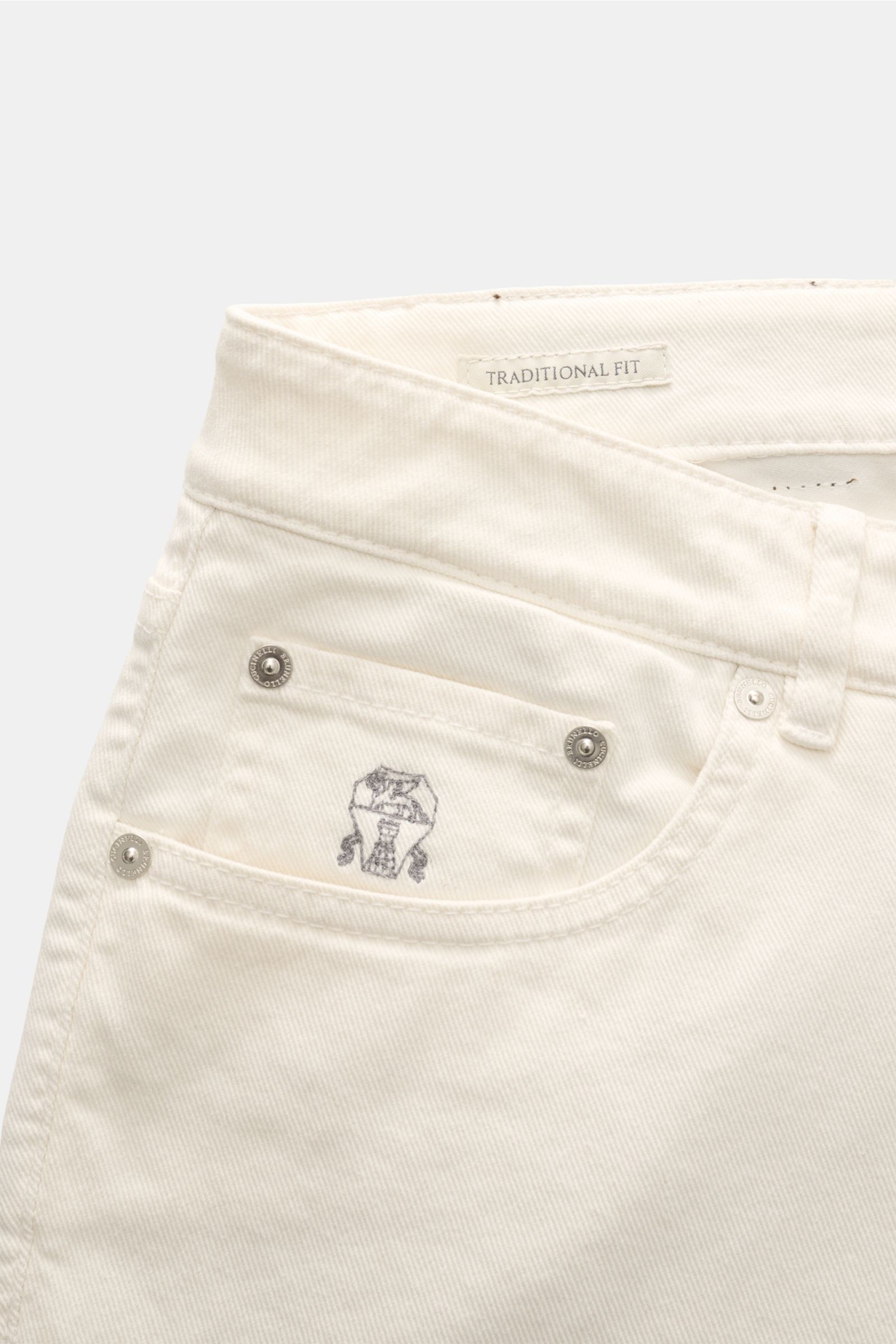 Close-up front view of Brunello Cucinelli Jeans 'Traditional Fit' cream, showing cotton denim fabric, button fly, five-pocket style with logo stitching and leather patch. A luxurious denim classic from BRUNELLO CUCINELLI: The versatile jeans 'Tradition