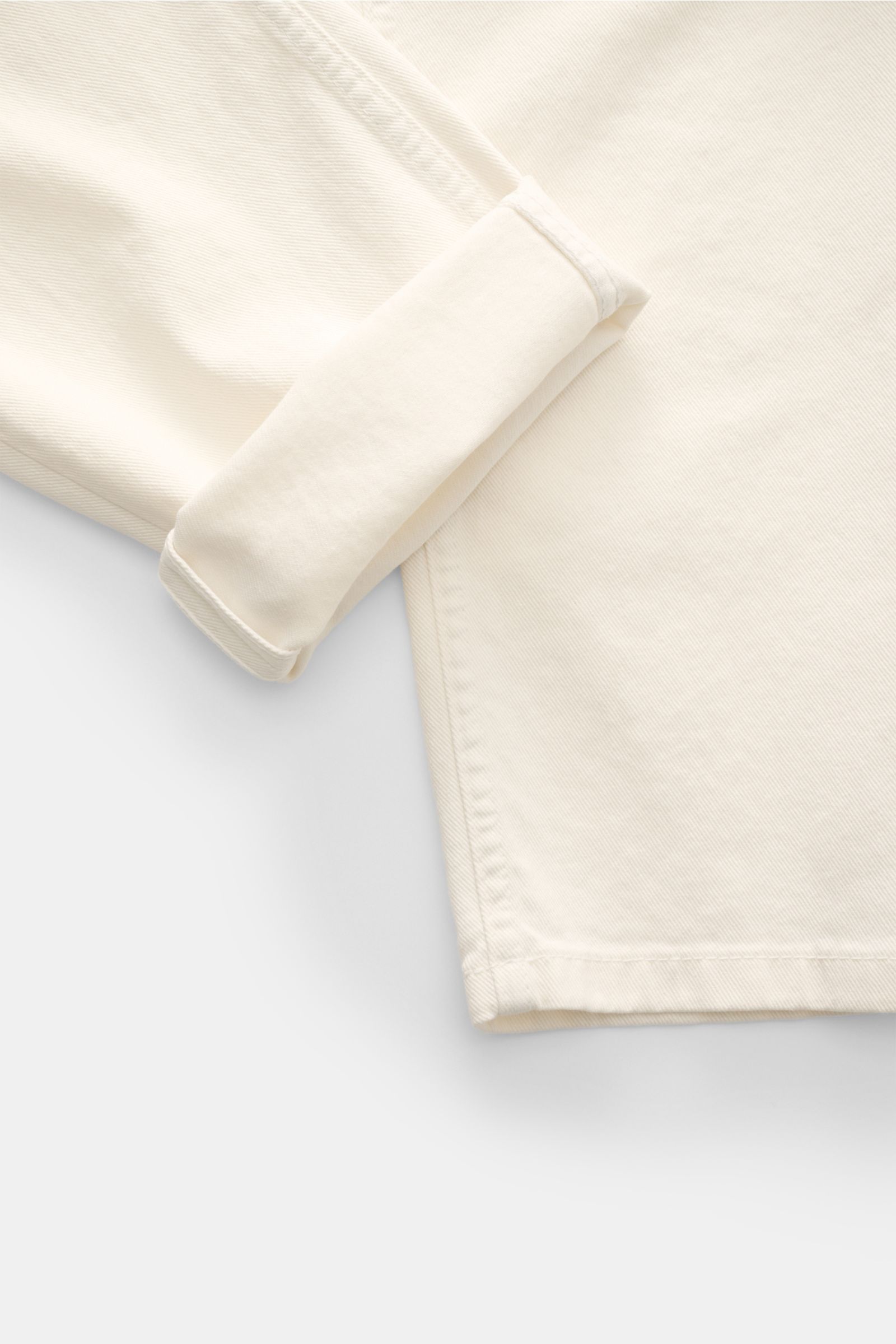 Close-up of the cuff and lower leg seam of Brunello Cucinelli Jeans 'Traditional Fit' cream, photographed from a top-down angle. A luxurious denim classic from BRUNELLO CUCINELLI: The versatile jeans 'Traditional Fit' in a relaxed fit with an authentic wa