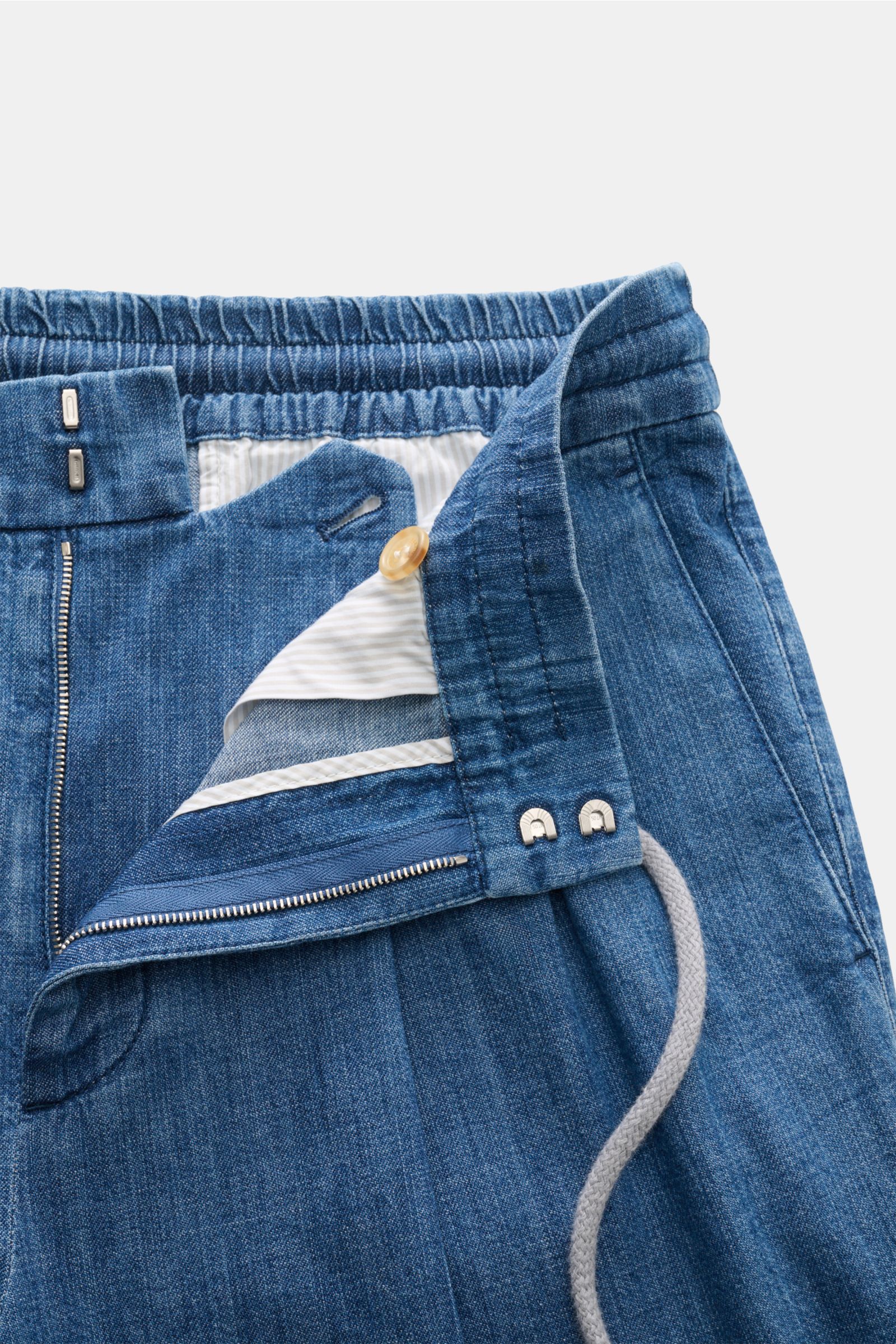 Close-up front view of Brunello Cucinelli Denim-Jogpants graublau showing elastic waistband, zipper, button, and drawstring details in blue cotton denim.

Komfort trifft Stil: Die Jogpants aus reinem Baumwoll-Denim von BRUNELLO CUCINELLI ist ein lässig