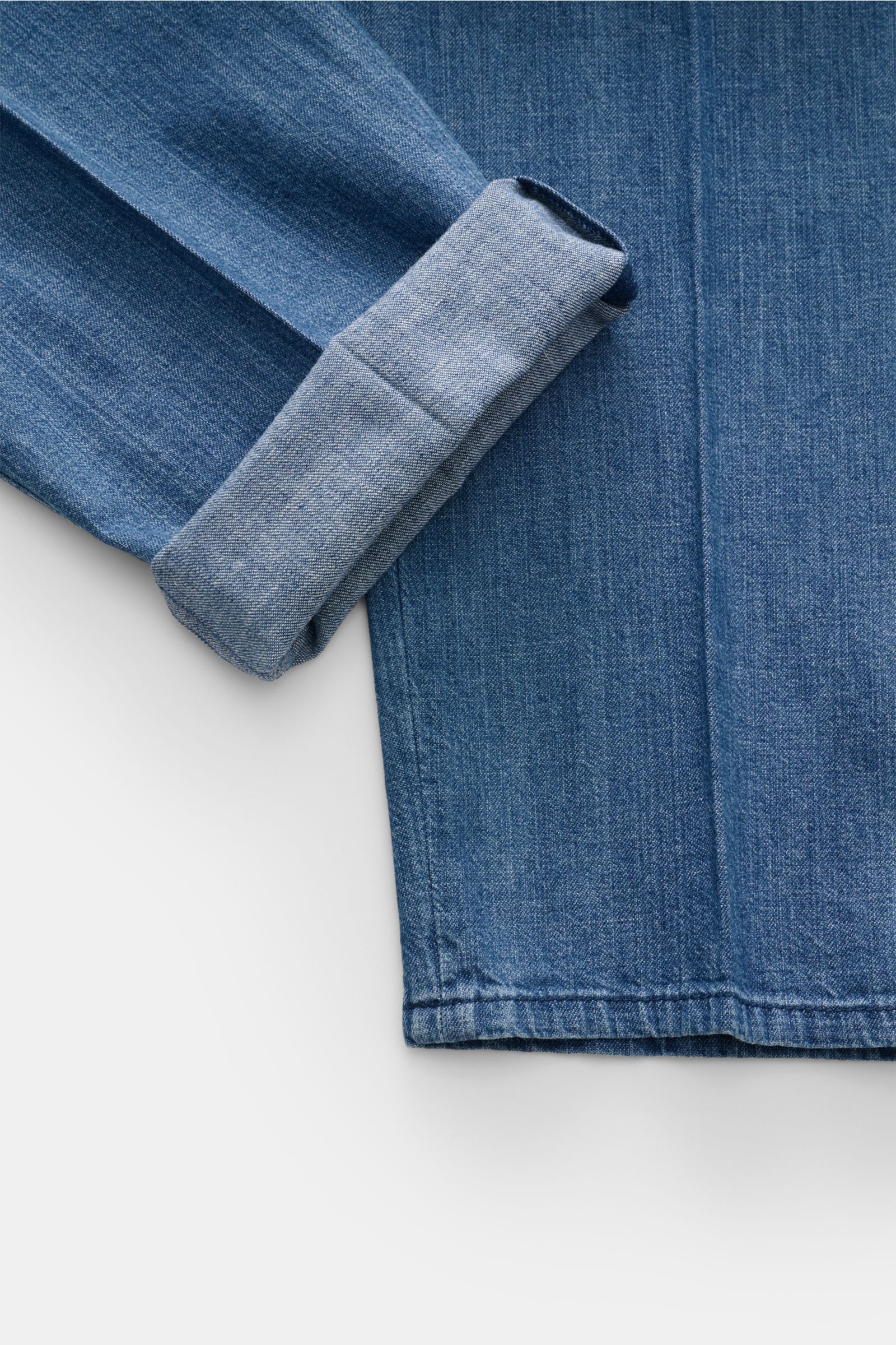 Close-up top view of Brunello Cucinelli Denim-Jogpants graublau showing folded cuff and fabric texture, made of cotton denim with regular fit and elastic waistband. Komfort trifft Stil: Die Jogpants aus reinem Baumwoll-Denim von BRUNELLO CUCINELLI ist 