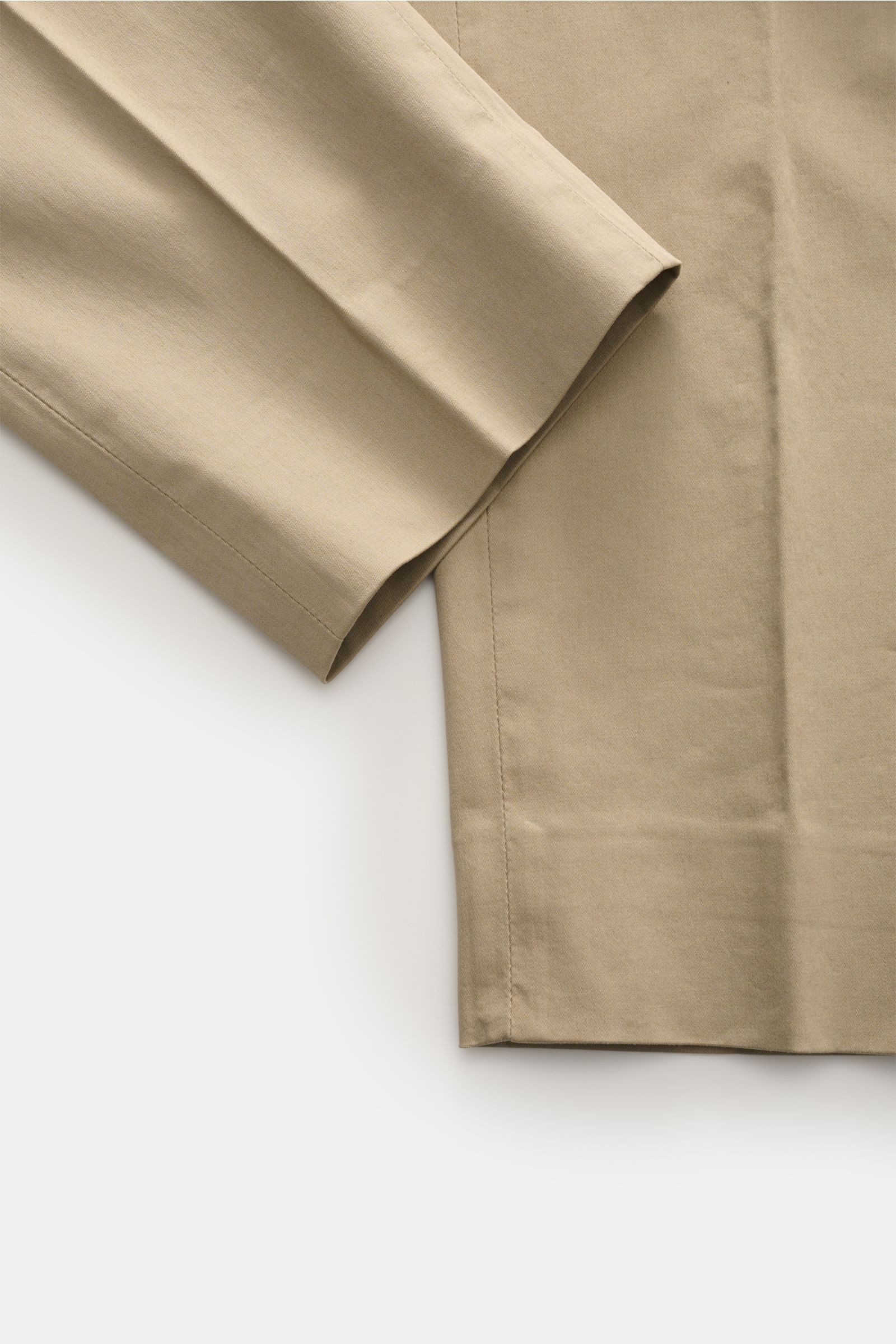 Nahaufnahme der beige GTA Chino 'Davide' aus Baumwoll-Twill, schmal zulaufendes Bein, Detailansicht vom Saum und Stoffstruktur.
