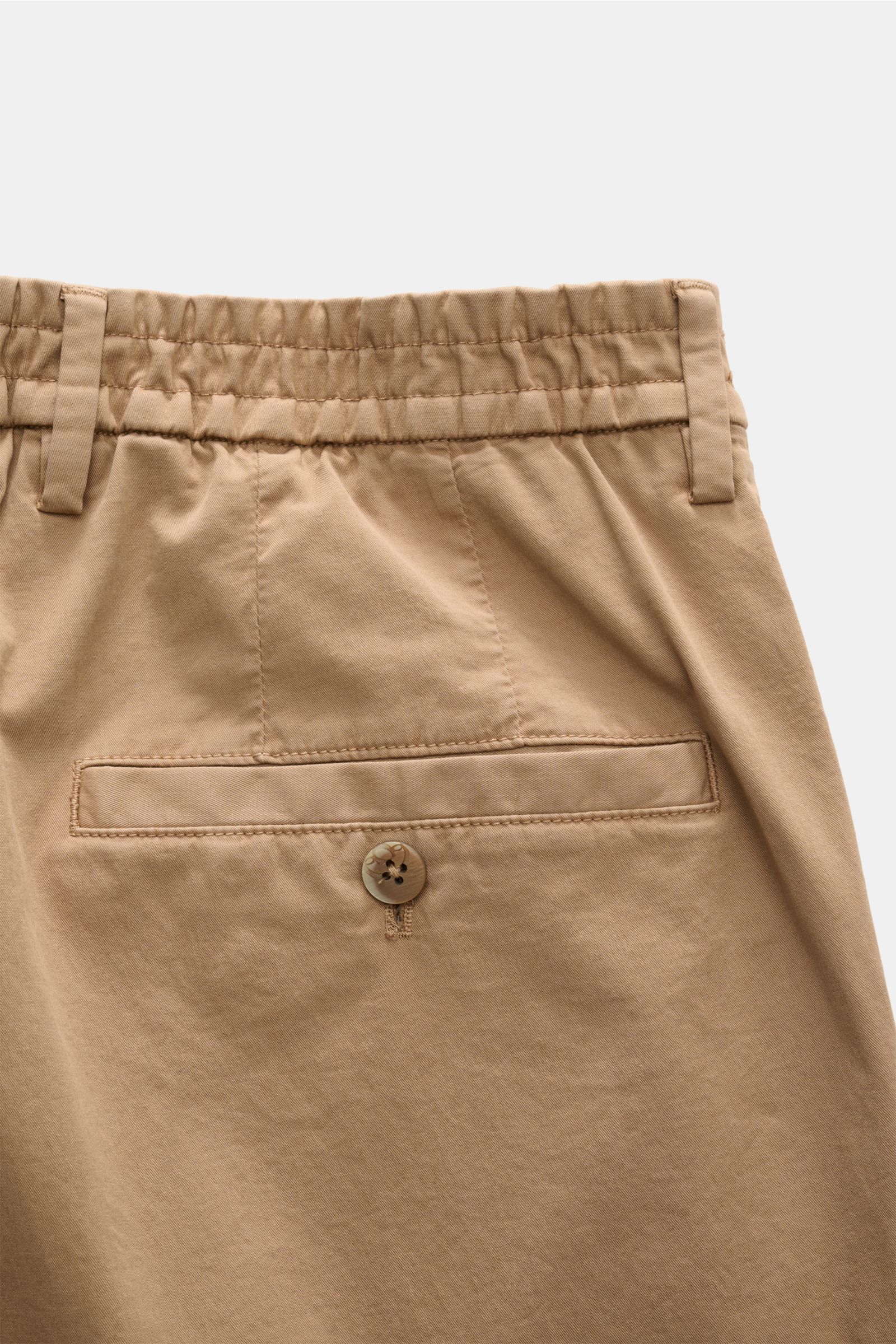 Close-up rear view of the waistband and back pocket of GTA Chino 'Davide' hellbraun in light brown cotton twill with elastic waistband, belt loops, buttoned back pocket, and smooth texture, showcasing high comfort and elegant silhouette.

