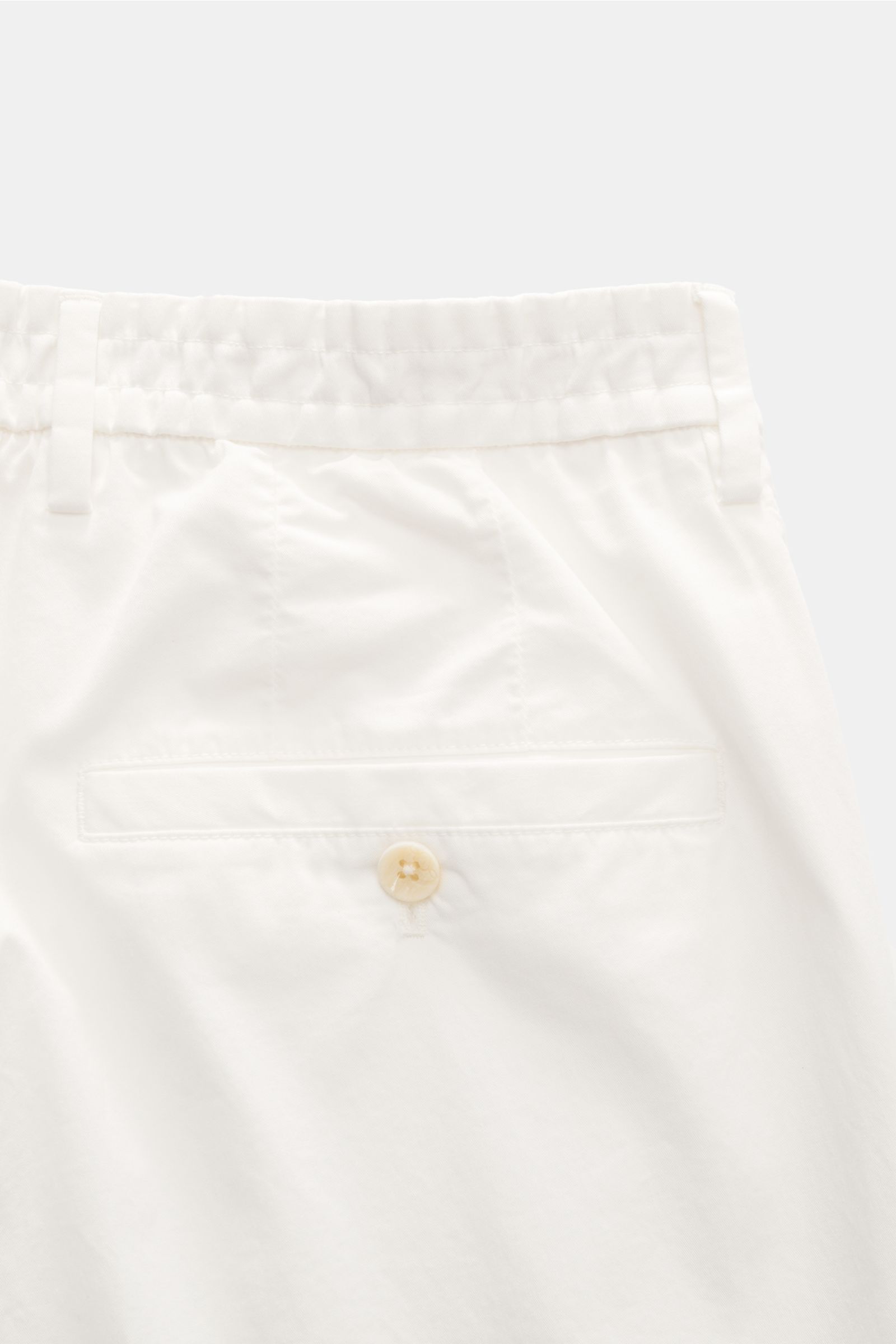 Close-up rear view of the GTA Chino 'Davide' creme made from pure cotton twill, featuring elastic waistband, buttoned back pocket, and smooth finish. 
