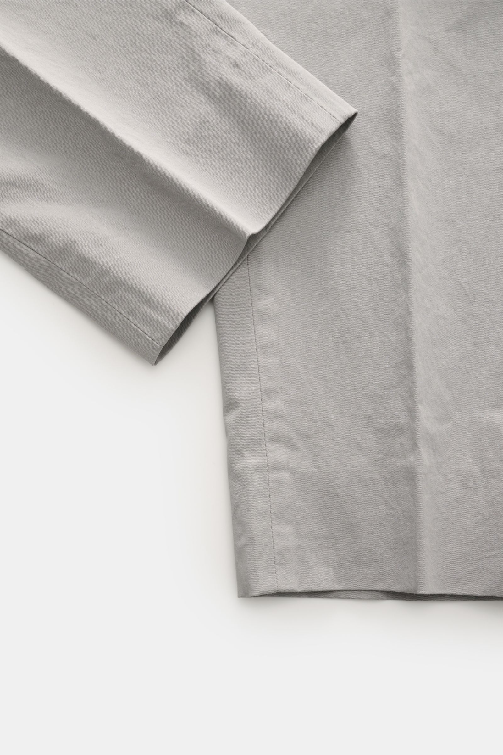 Close-up front-side view of GTA Chino 'Davide' grau made of pure cotton twill with elastic quality, regular fit, smooth texture, and fine stitching. 
