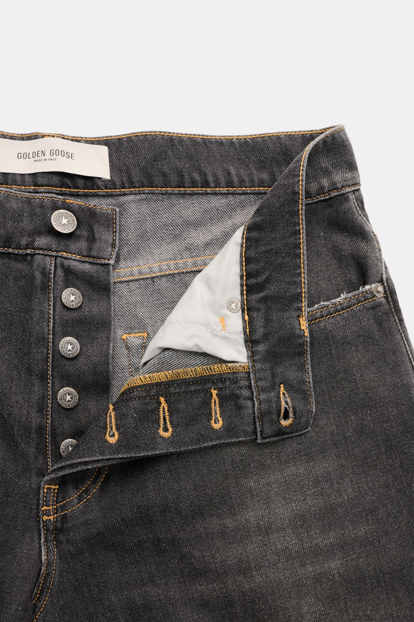 Golden Goose Jeans 'Skate Loose' dunkelgrau aus Baumwoll-Denim mit Button-Fly, Five-Pocket-Stil und dezenten Distressed-Details, Nahaufnahme von oben.