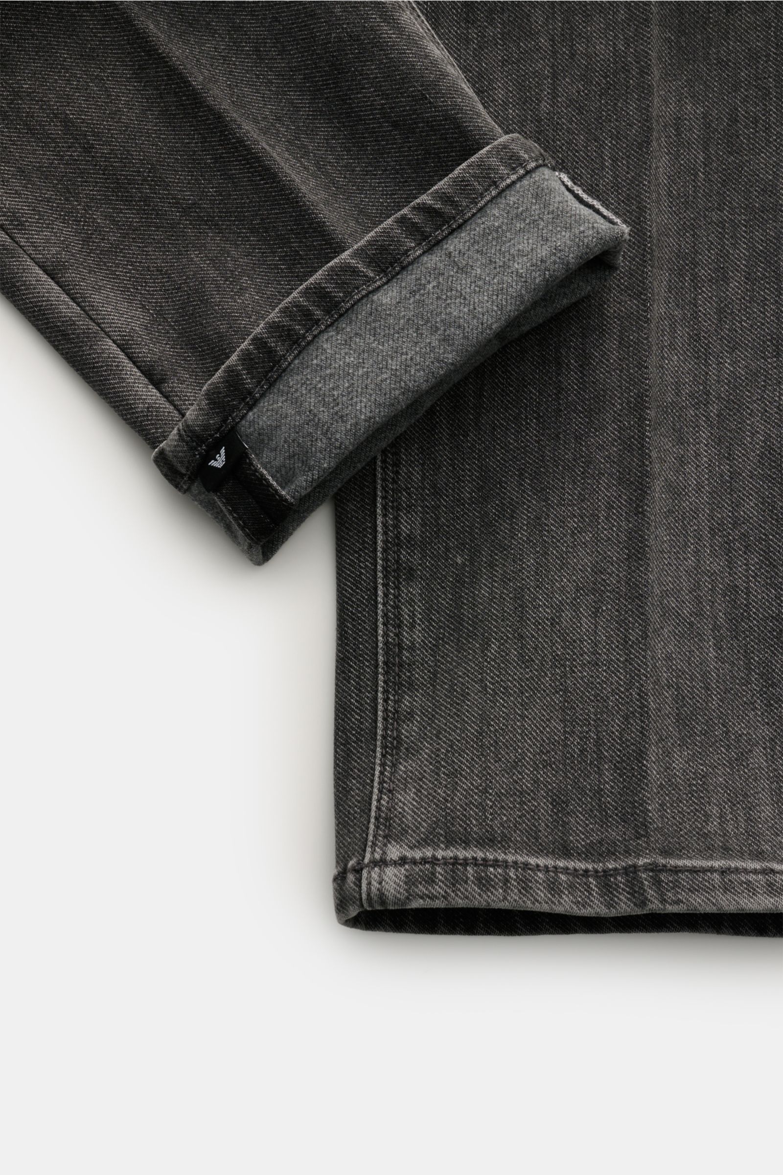 Emporio Armani Jeans dunkelgrau, Detailansicht Ärmel umgeschlagen, Baumwolle-Microfaser-Mix, elastisch, weicher Griff, Regular Fit, Five-Pocket, Zip Fly, Metall-Logos, Leather Patch.