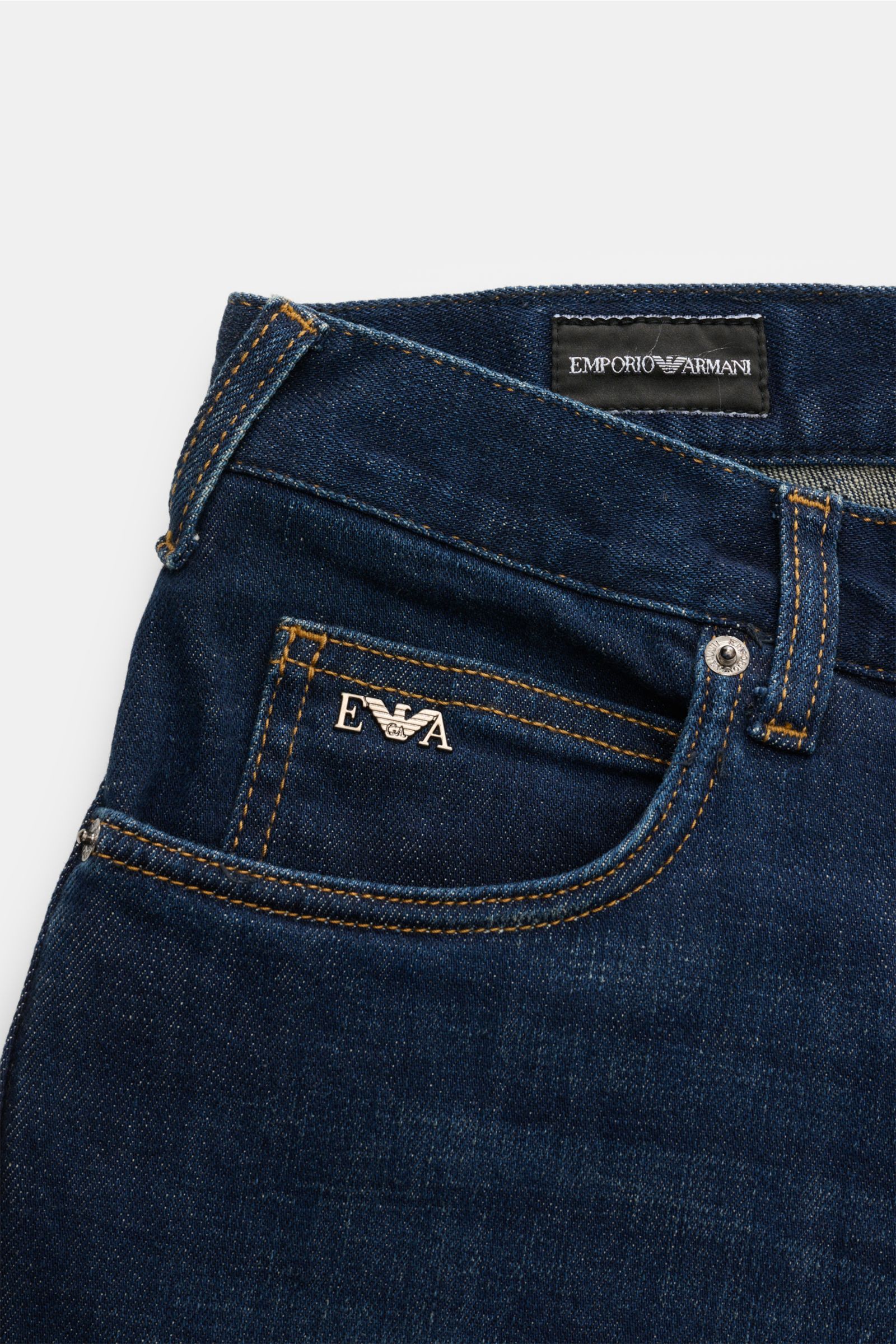 Emporio Armani Jeans navy, Nahaufnahme der Slim-Fit-Jeans mit dezenter Used-Waschung, Metall-Logo an Münztasche, Five-Pocket-Stil, Baumwoll-Denim mit Stretch.