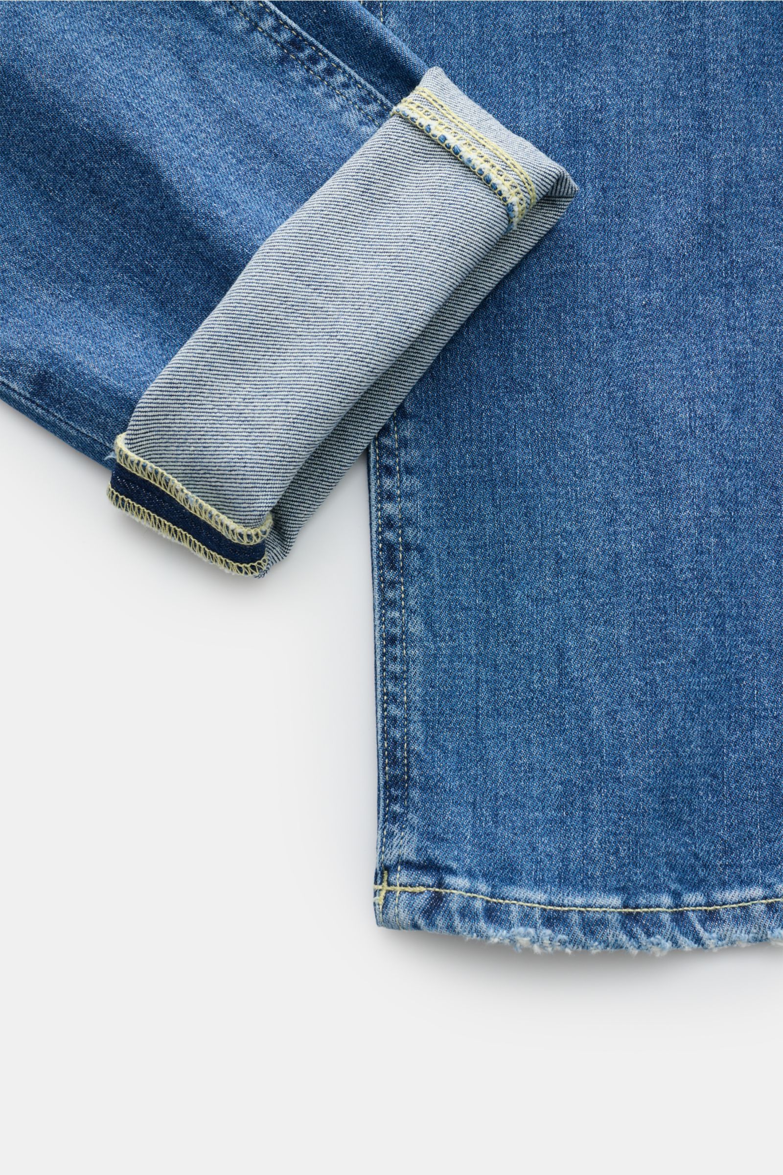 Nahaufnahme der aufgeschlagenen Beinöffnung der Dondup Jeans 'George' blau aus Baumwoll-Denim mit leichtem Stretch, weichem Griff, Skinny Fit, authentischer Waschung und Distressed-Effekten.