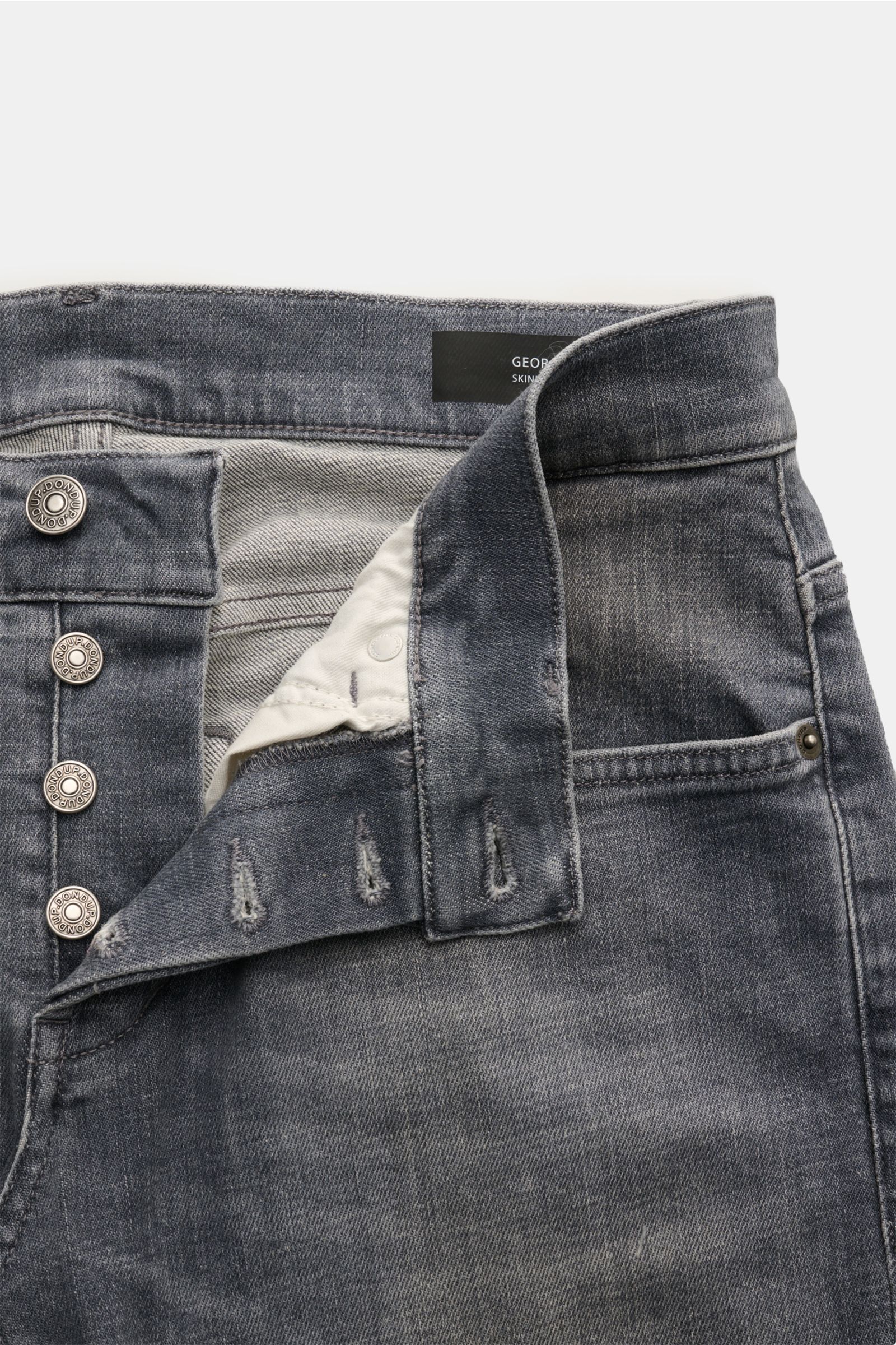 Front close-up view of Dondup Jeans 'George' grau made of cotton denim with elastic quality, soft touch, skinny fit, narrow calf, low waist, button fly, five-pocket style, piped coin pocket, back pockets with stitching, typical metal initial, and inner wo