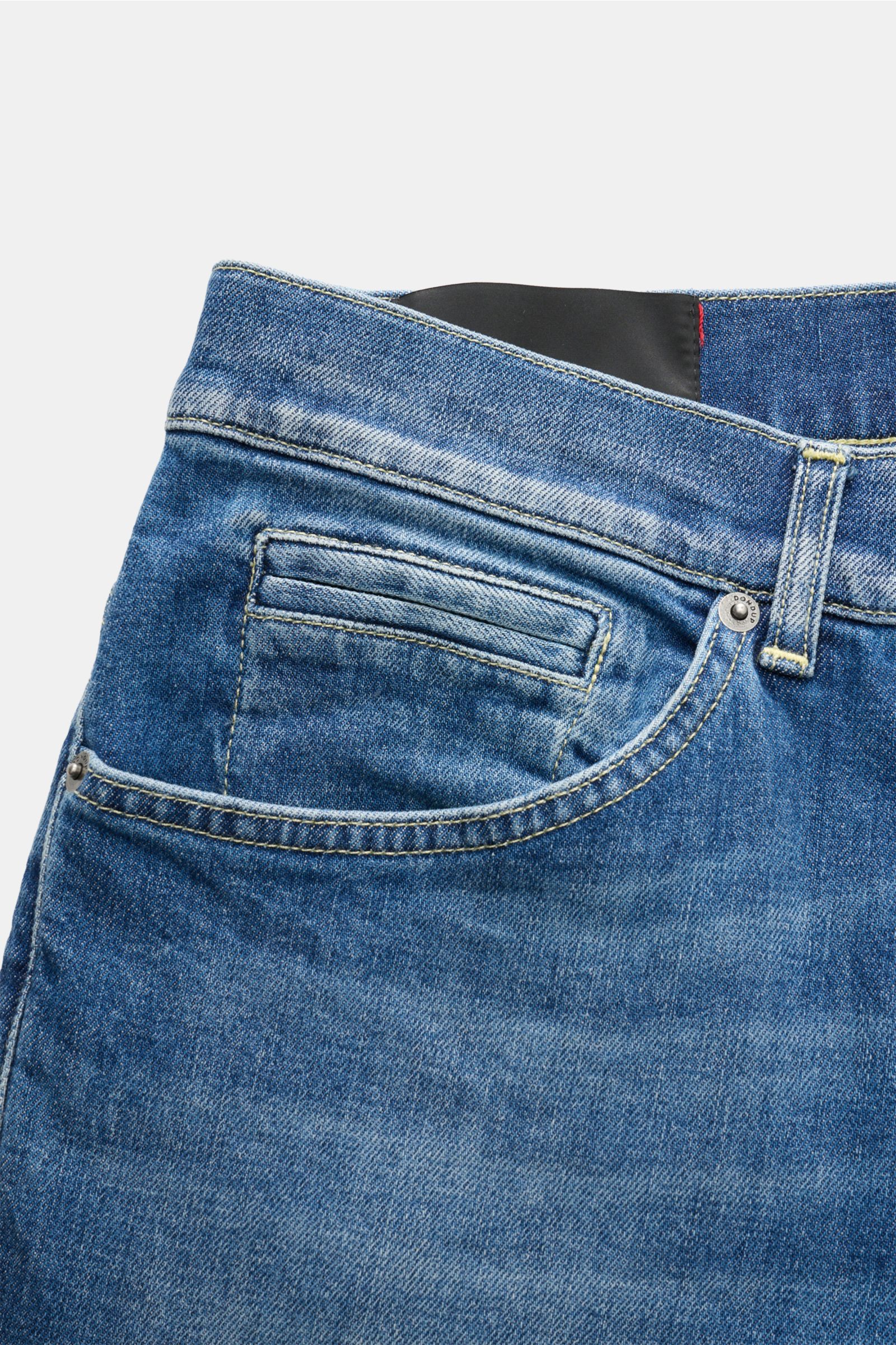 Close-up front angled view of Dondup Jeans 'George' blue denim made of cotton with slight stretch, soft feel, skinny fit, slim calf, authentic wash, button fly, five-pocket style including jetted coin pocket, back pockets with stitching, signature metal i