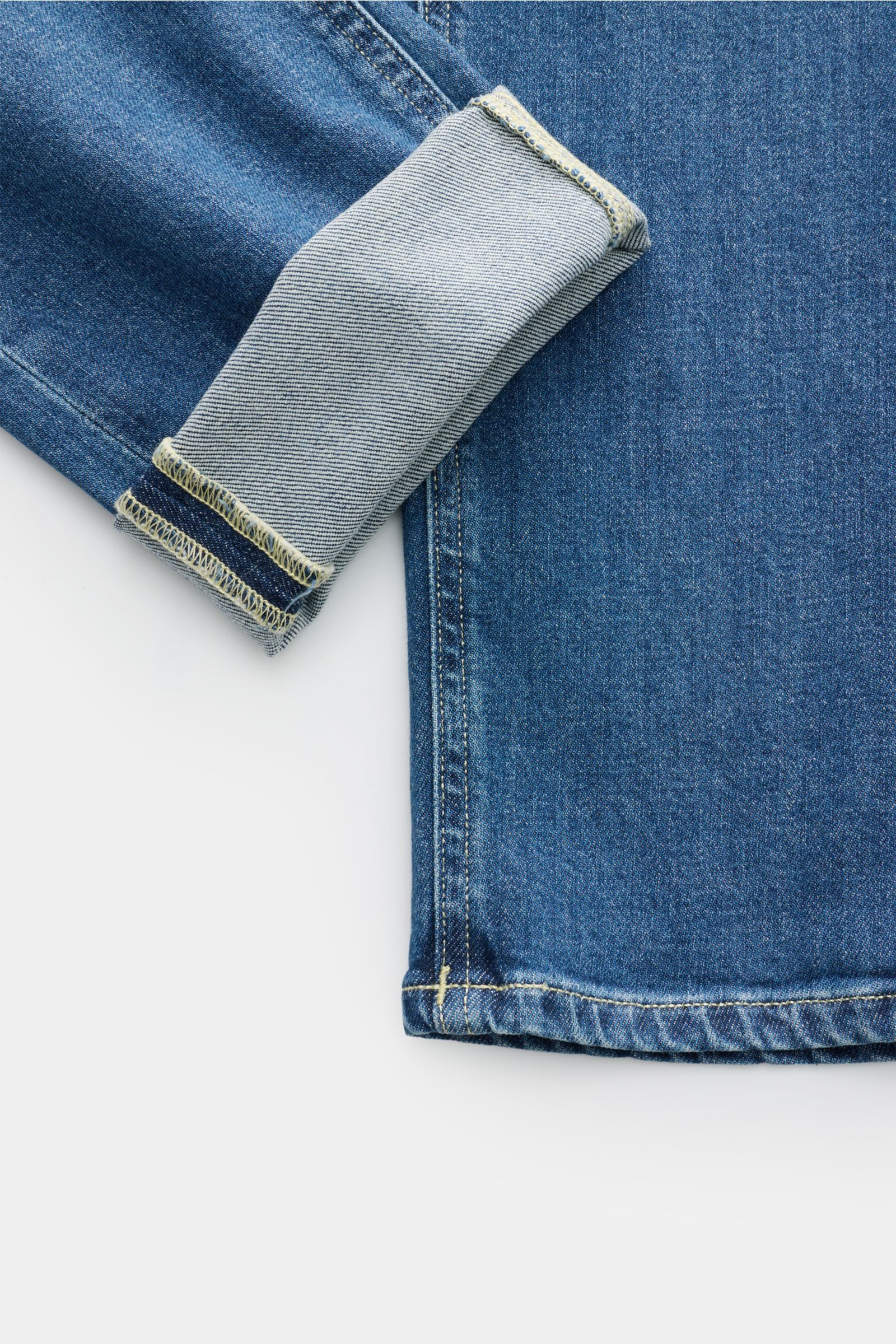 Close-up front view of Dondup Jeans 'George' blue showing denim cotton fabric with slight stretch, soft feel, skinny fit, slim calf, authentic wash, button fly, five-pocket style, jetted coin pocket, back pockets with stitching, signature metal initial, a