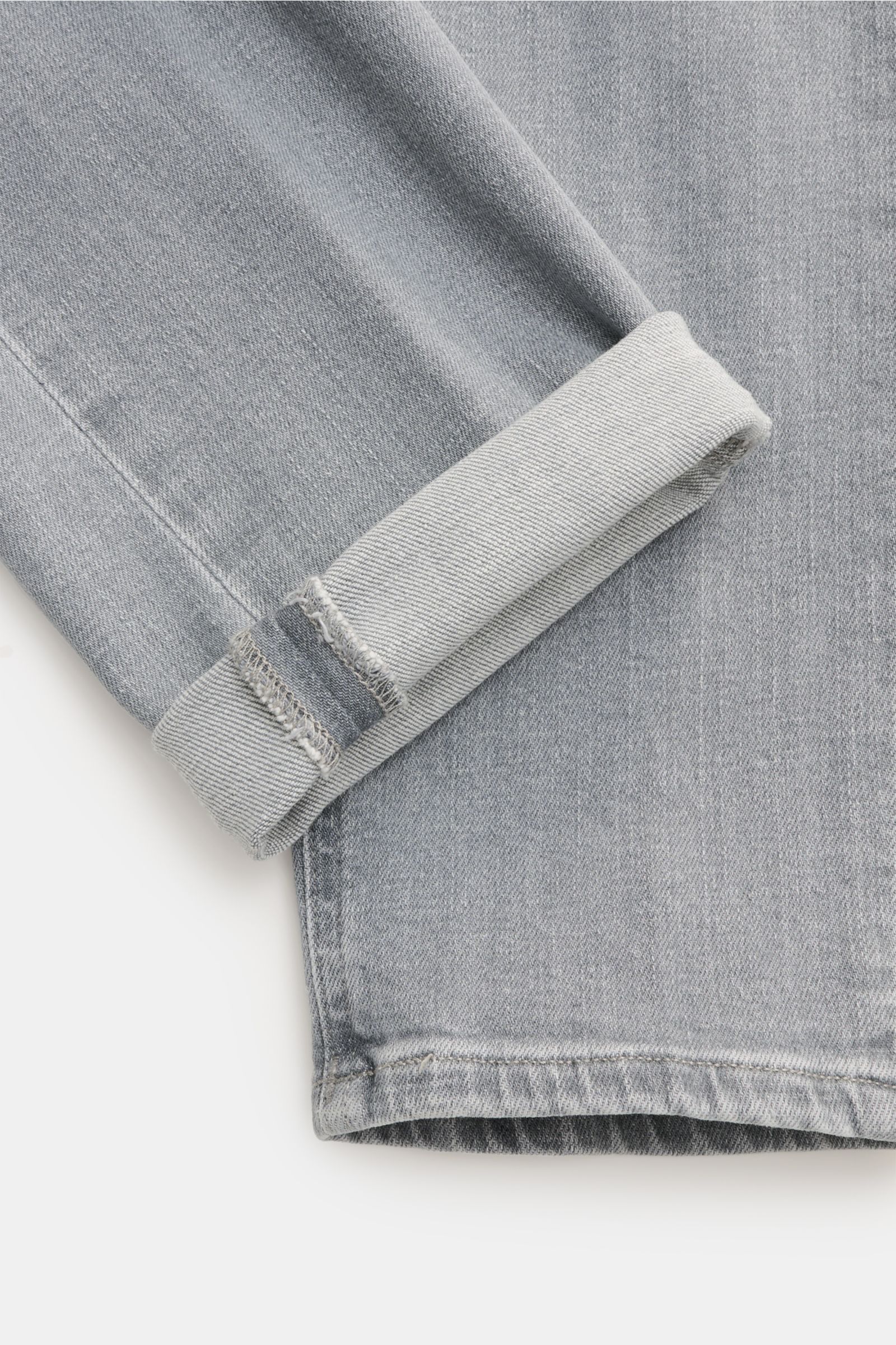 Nahaufnahme der Dondup Jeans 'George' grau im Skinny Fit aus Baumwoll-Denim, elastisch und weich, mit schmaler Wade, Button Fly, Five-Pocket-Stil, paspelierter Münztasche, gesteppten Gesäßtaschen, Metall-Initial und innenliegendem Weblabel, fotografiert v