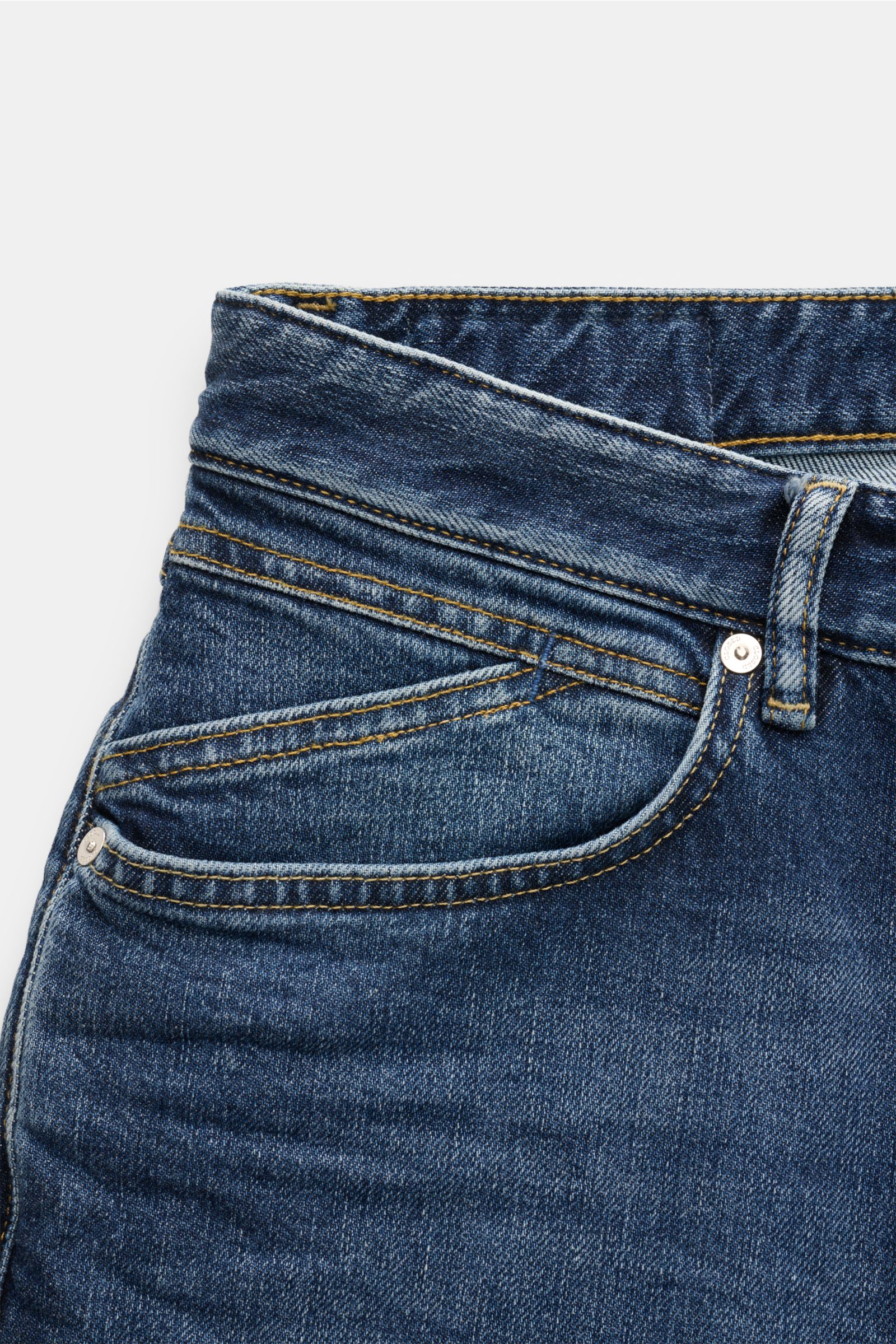 Nahaufnahme der Closed Jeans 'Cooper' dunkelblau aus Baumwolle mit leichtem Stretch, Slim Fit, Five-Pocket-Stil, Zip Fly, typischem Weblabel und rückwärtigem Patch, fotografiert von vorne oben.