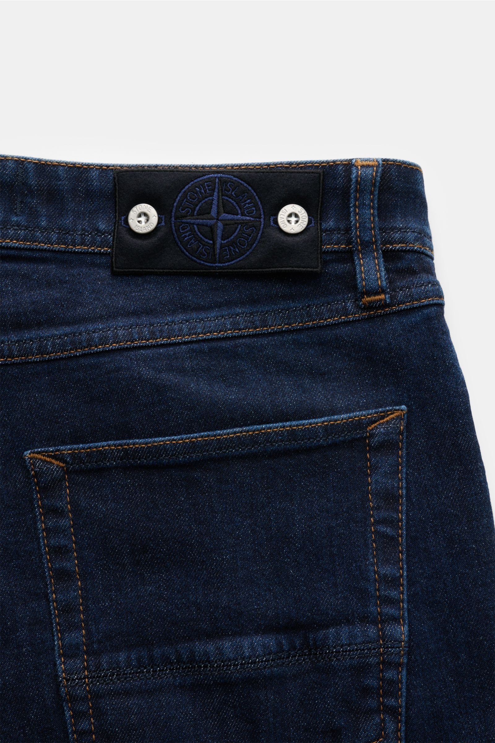 Stone Island Jeans 'Stretch Indigo Denim - Rinsed' dunkelblau, Rückansicht auf Bund mit Kompass-Badge, Slim Fit, elastische Baumwolle.