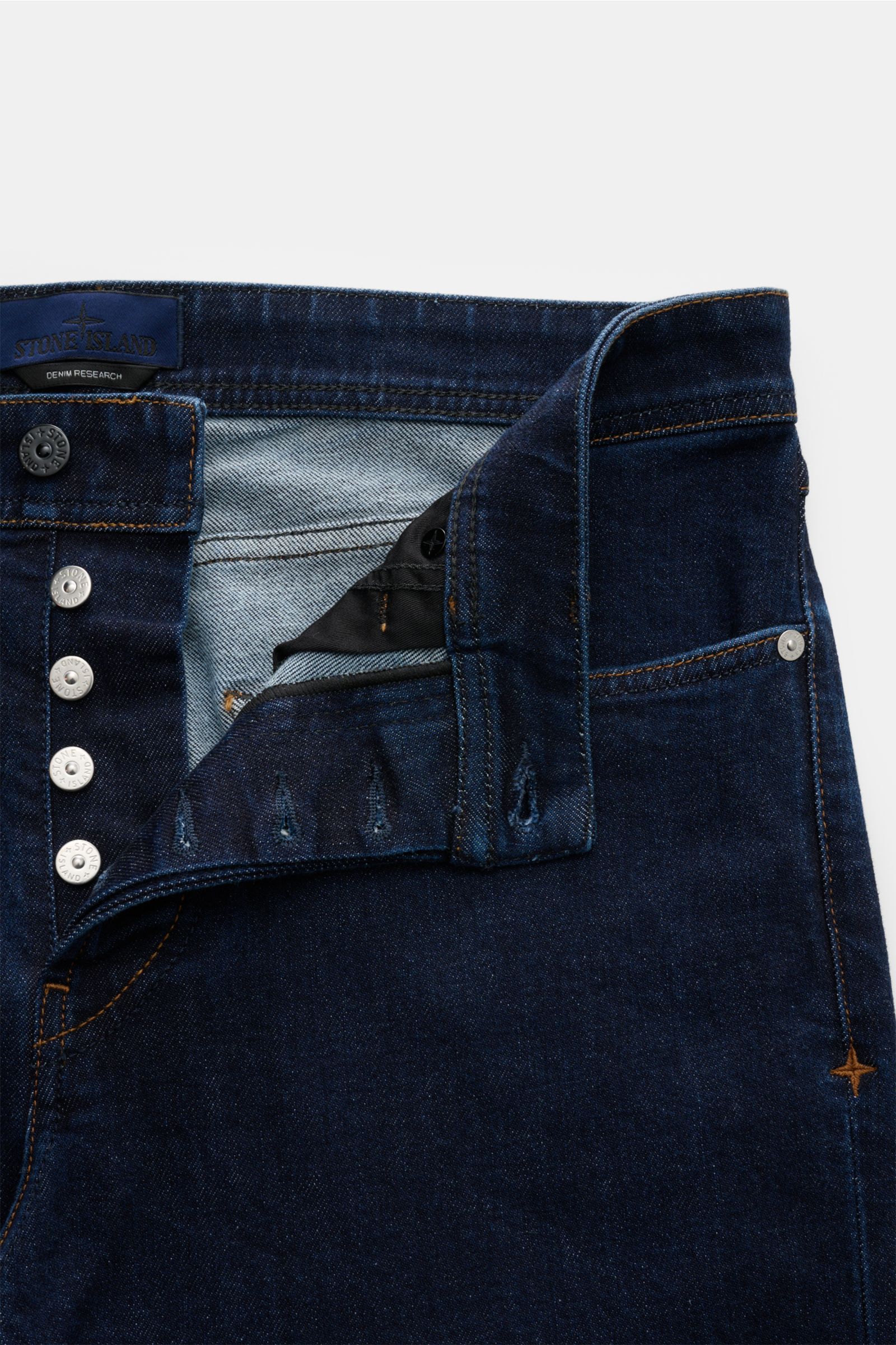 Stone Island Jeans 'Stretch Indigo Denim - Rinsed' dunkelblau, Slim Fit, sehr schmal zulaufend mit Button Fly, Five-Pocket-Stil und Kompass-Badge, Frontansicht.