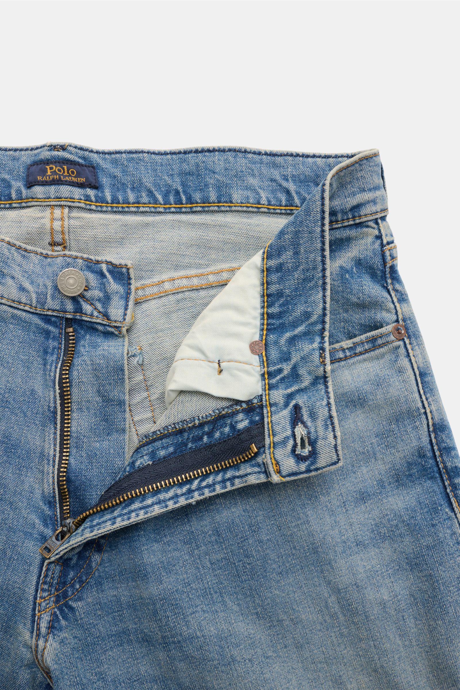 Polo Ralph Lauren Jeans rauchblau, Frontansicht mit offenem Reißverschluss, Button Fly, Five-Pocket-Stil, Used-Waschung, Baumwoll-Denim mit Stretch, Regular Fit, Weblabel und Polo-Reiter-Stitching.