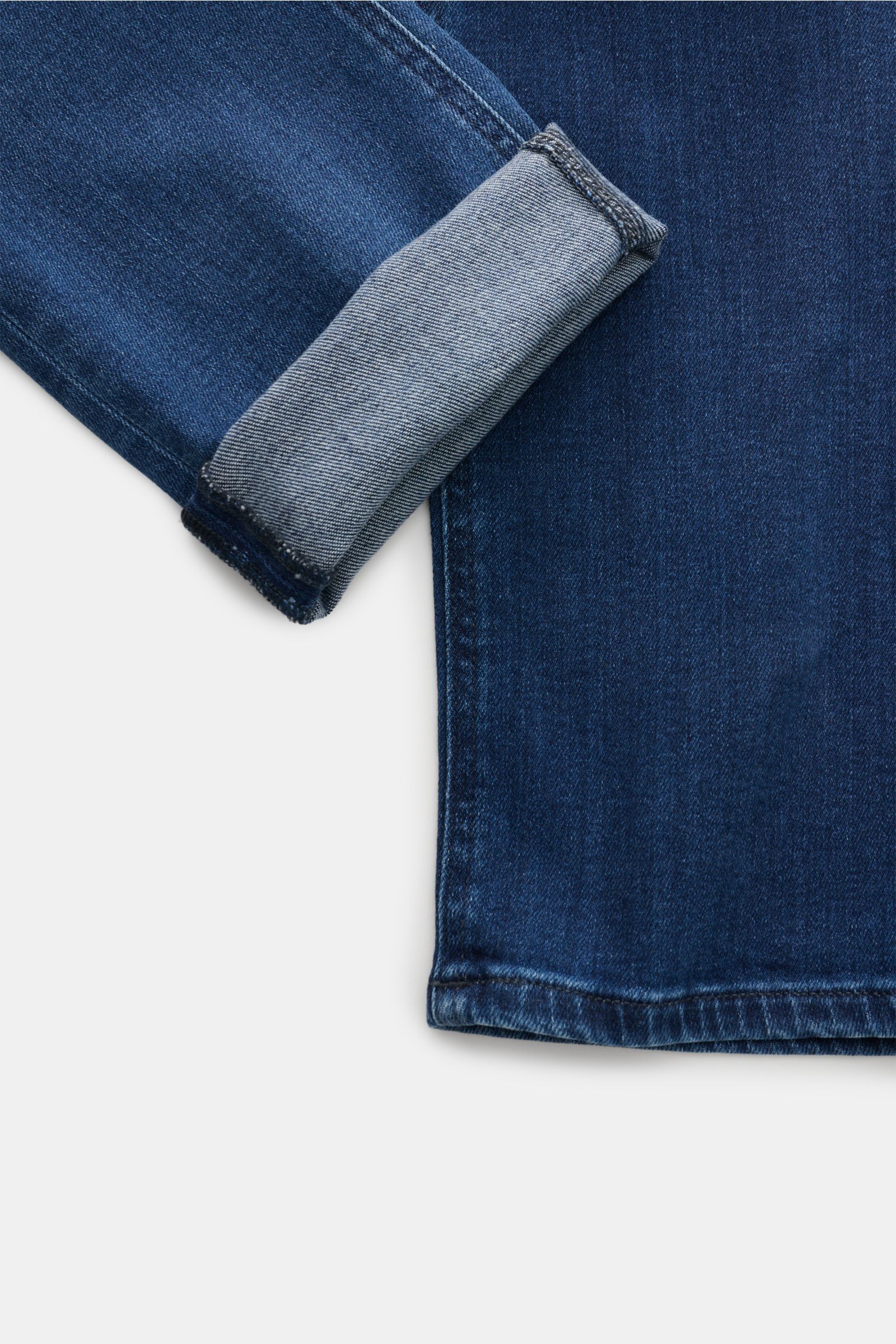 Close-up, top-down view of the cuff and lower leg of PT Torino Denim Jeans 'Jazz' dunkelblau, showing dark blue slim fit denim with high stretch and soft grip, subtle used wash, narrow tapered leg, five-pocket style, zip fly, cotton and lyocell fabric, an
