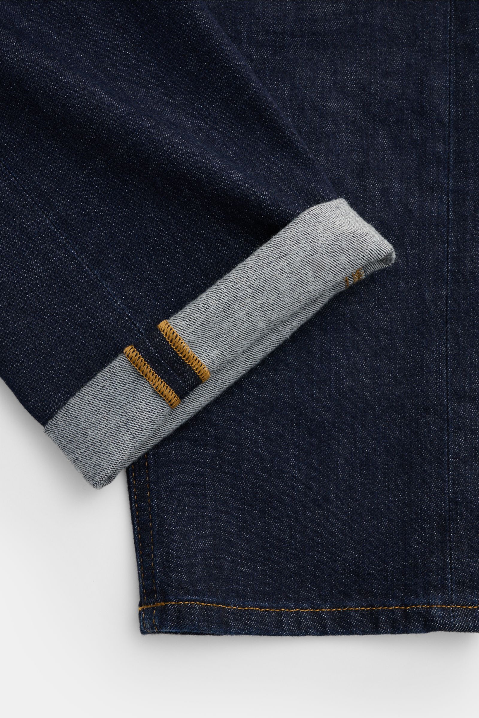HandPicked Jeans 'Verona' navy im Detail, Nahaufnahme der umgeschlagenen Saumkante, Denim aus Baumwolle mit leichtem Stretch, weicher Griff, Tapered Fit, kurzer Schnitt, Button Fly, Five-Pocket-Stil, Leather Patch, authentischer Indigo-Look.