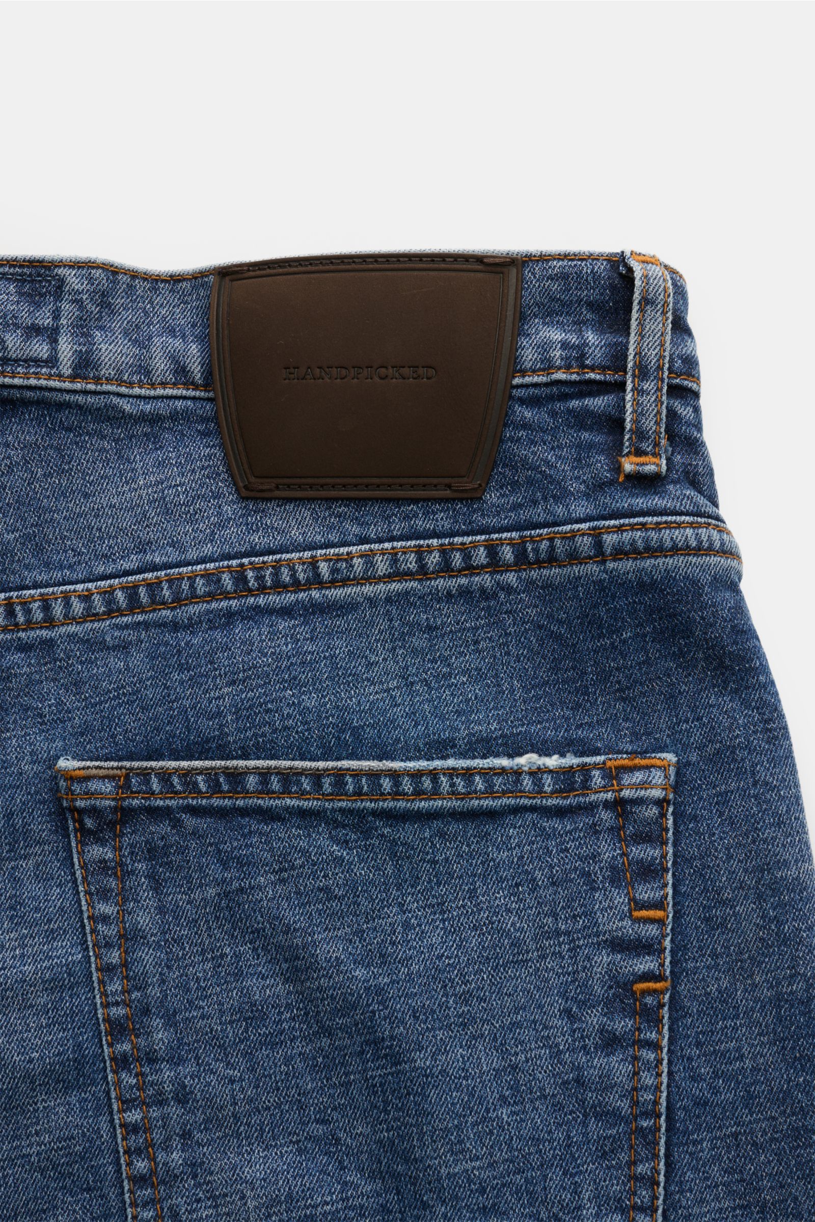 Close-up rear view of HandPicked Jeans 'Ravello' graublau showing denim aus Baumwolle, leichter Stretch-Anteil, fester Griff, authentische Used-Waschung, Slim Fit, schmal zulaufend, Button Fly, Five-Pocket-Stil, and Leather Patch mit Stitching.