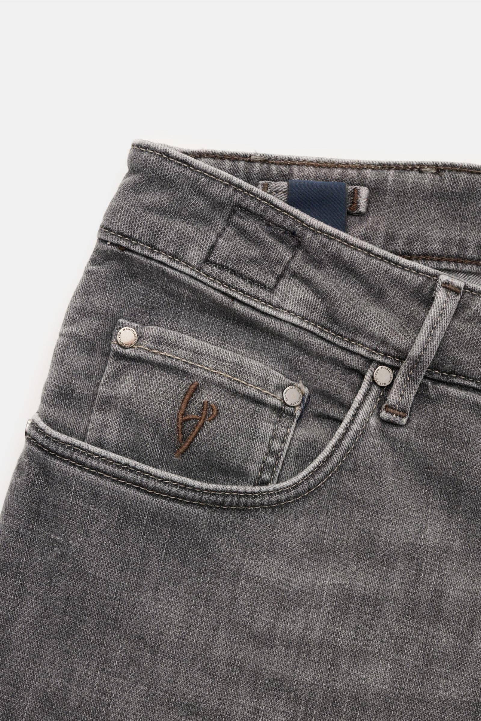 HandPicked Jeans 'Ravello' grau, Nahaufnahme schräg von oben, Denim aus Baumwolle und Microfaser, elastisch, weich, Slim Fit, Button Fly, Five-Pocket, Münztasche mit Initial, Gesäßtaschen mit Stitching, Leather Patch, Used-Waschung.