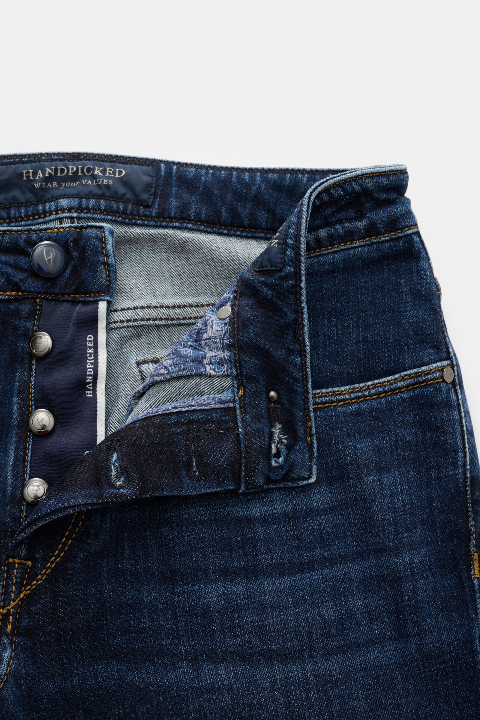 Close-up front view of HandPicked Jeans 'Ravello' navy showing button fly, branded buttons, denim texture, and leather patch.

HAND PICKED celebrates the love of denim with fine details like high-gloss, branded buttons and genuine indigo dye. The resul