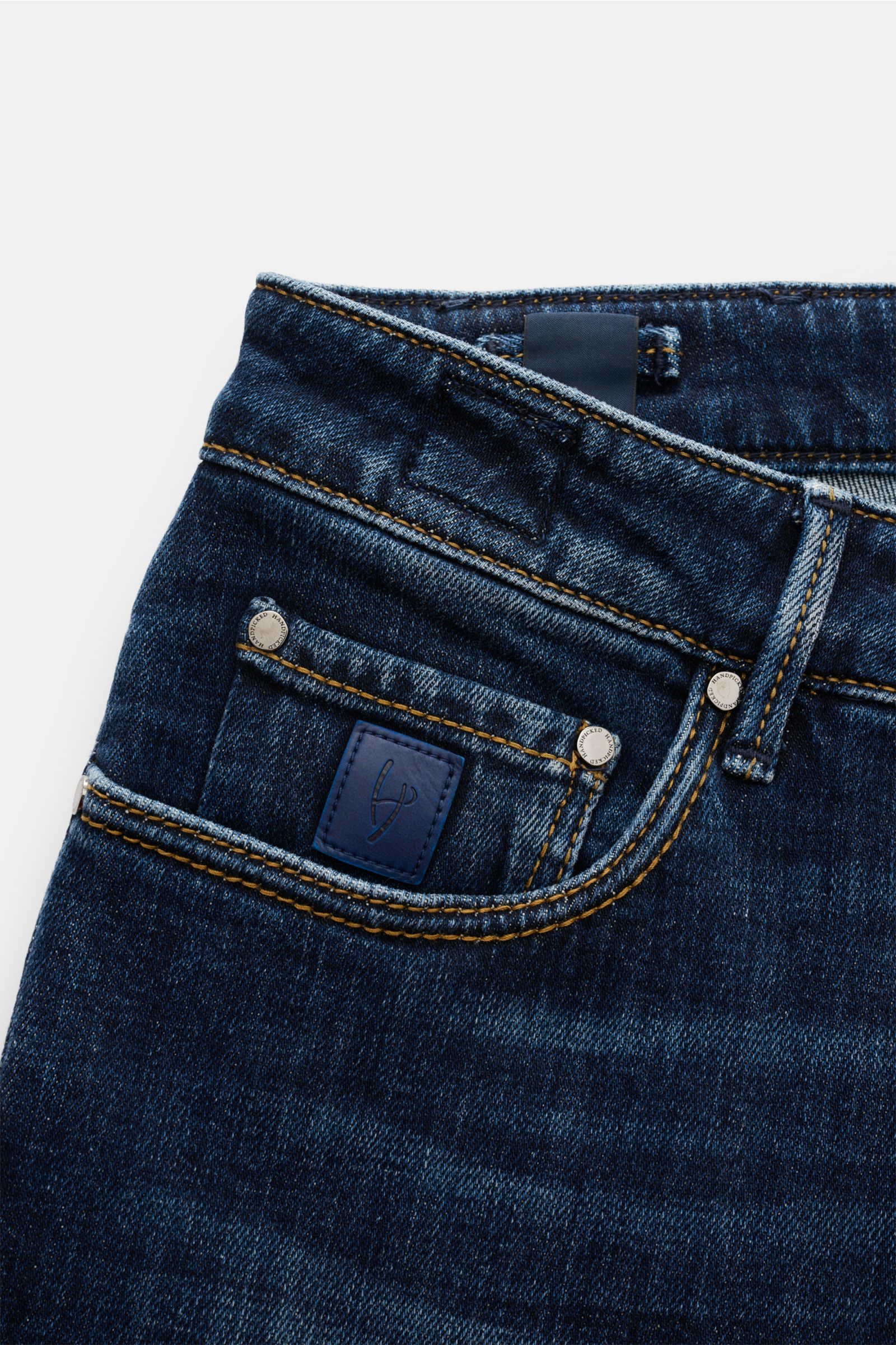 Close-up front-side view of HandPicked Jeans 'Ravello' navy, showing denim texture, branded buttons, and leather patch on the pocket.

Description: HAND PICKED celebrates the love of denim with fine details like high-gloss, branded buttons and genuine 