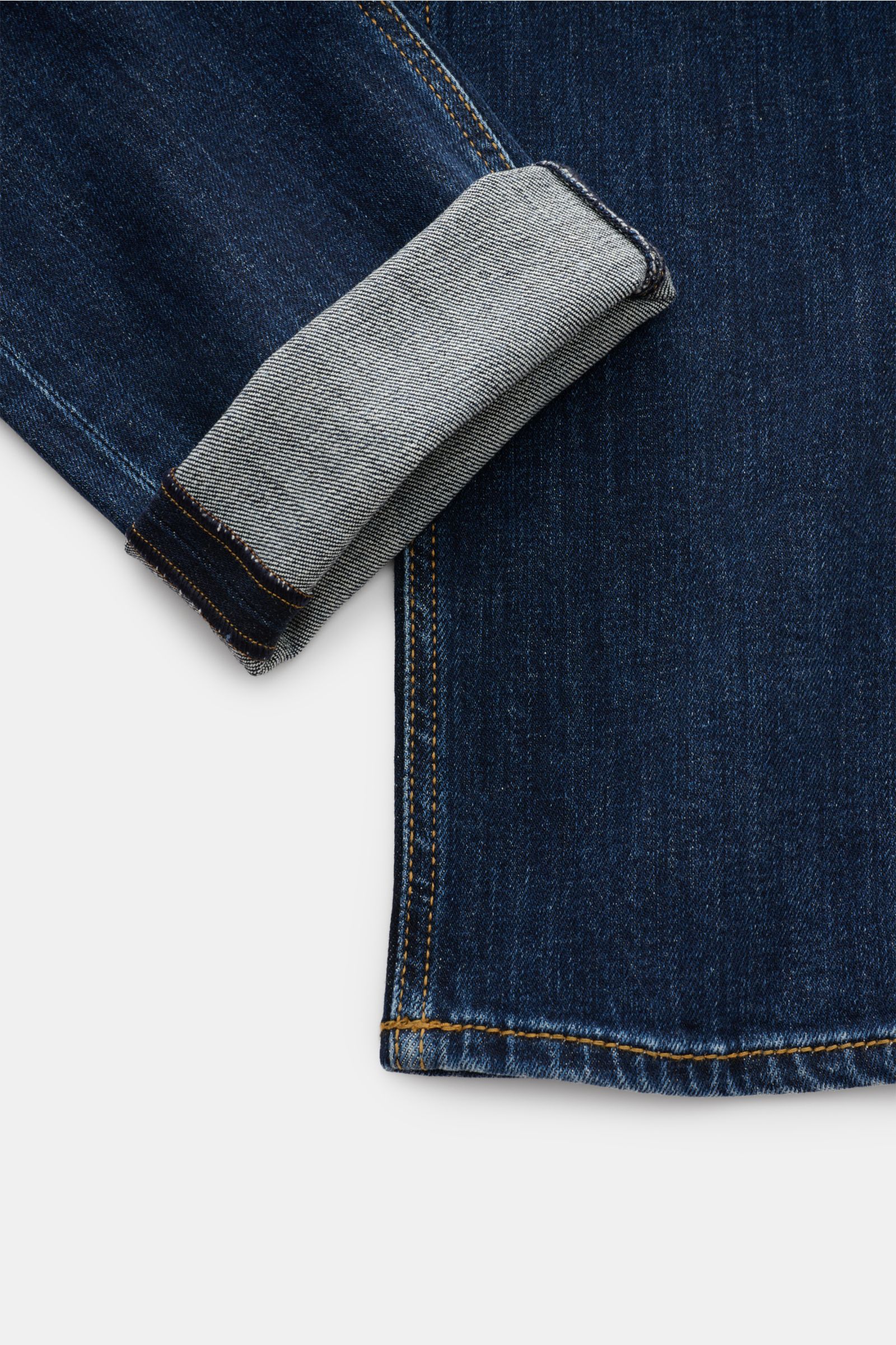Close-up side view of the cuff of HandPicked Jeans 'Ravello' navy, showing the folded hem with authentic indigo dye and soft cotton denim.

HAND PICKED celebrates the love of denim with fine details like high-gloss, branded buttons and genuine indigo d