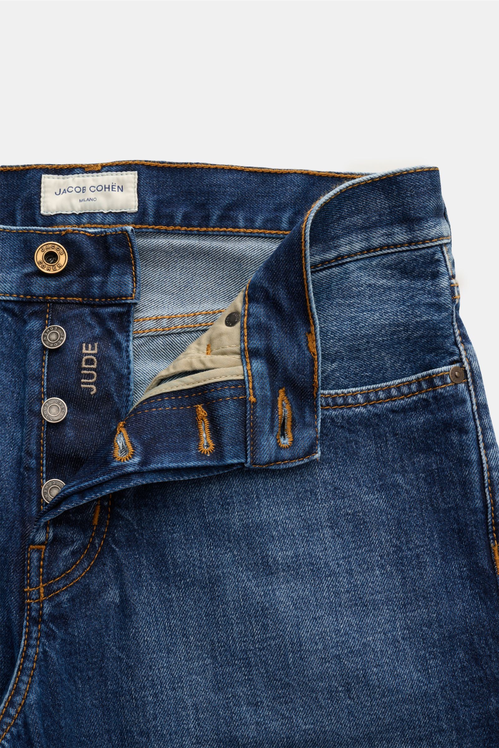 Close-up front view of Jacob Cohen Jeans 'Jude' blau showing denim aus reiner Baumwolle, griffige Haptik, kontrastierende Nähte, Button Fly, Five-Pocket-Stil, Münztasche mit Initial, Leather Patch in Vintage-Optik, tapered fit, reguläre Oberschenkelweite,
