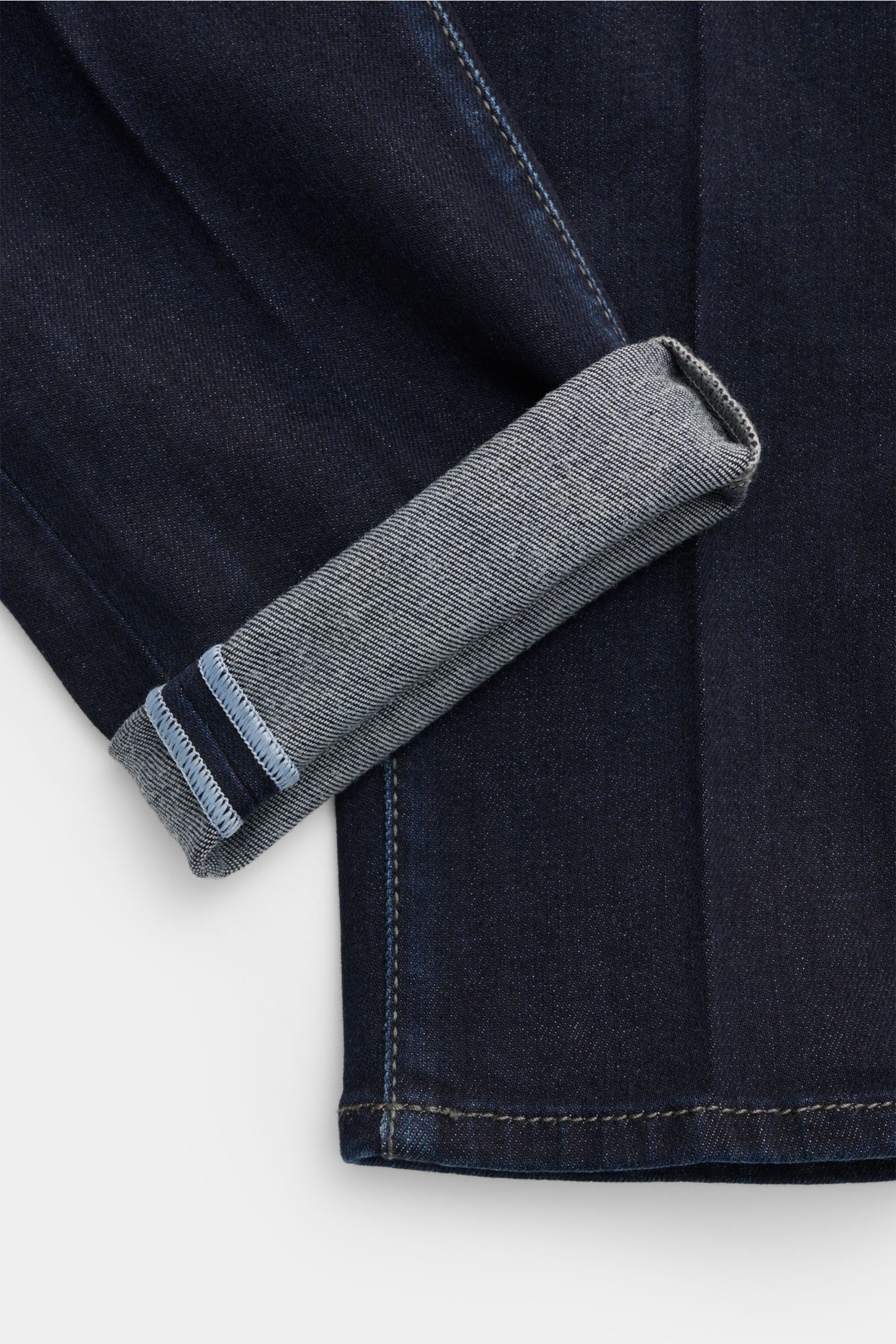 Close-up view of the cuff of Jacob Cohen Jeans 'Scott' navy, showing denim made from cotton, lyocell, and microfiber, elastic quality, soft feel, subtle used wash, slim fit, ankle length, very tapered, button fly, five-pocket style, coin pocket with initi