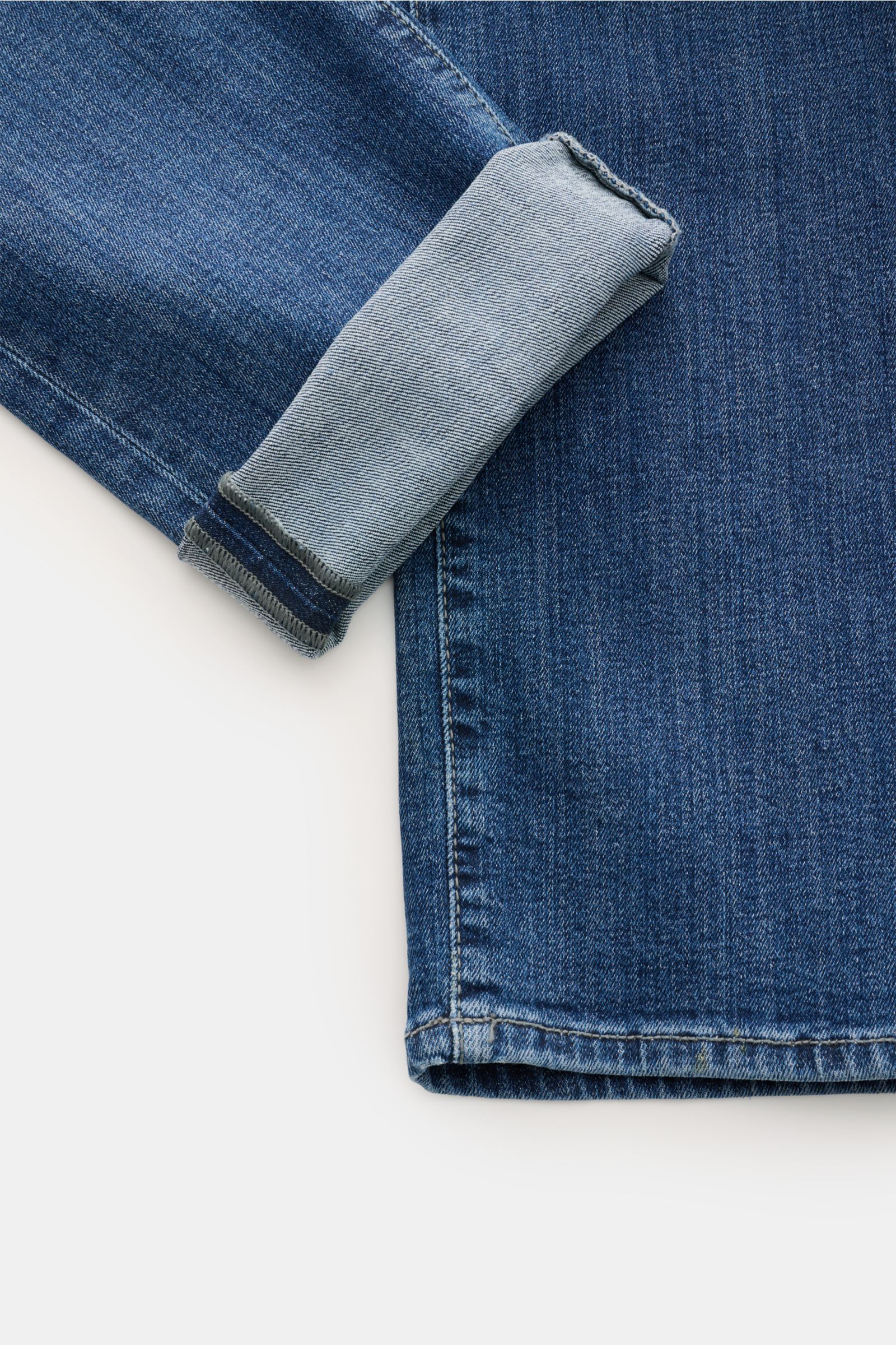 Jacob Cohen Jeans 'Bard' blau, Detailaufnahme vom Bein mit hochgekrempeltem Saum, Denim aus Baumwolle, leicht elastisch, Slim Fit, Button Fly, Five-Pocket-Stil, Münztasche mit Initial, Gesäßtaschen mit Stitching, Leather Patch in Ponyfell-Optik, schmal zu