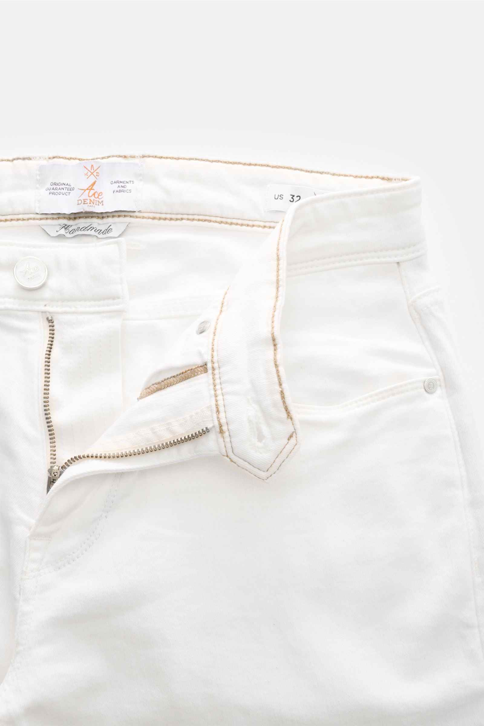 Close-up front view of Ace Denim Jeans 'AD 15' off-white with button fly, five-pocket style, woven patch, and beige stitching details.  

ACE DENIM stands for hand-made jeans and sustainable production processes – the model 'AD 15' is made of a materia