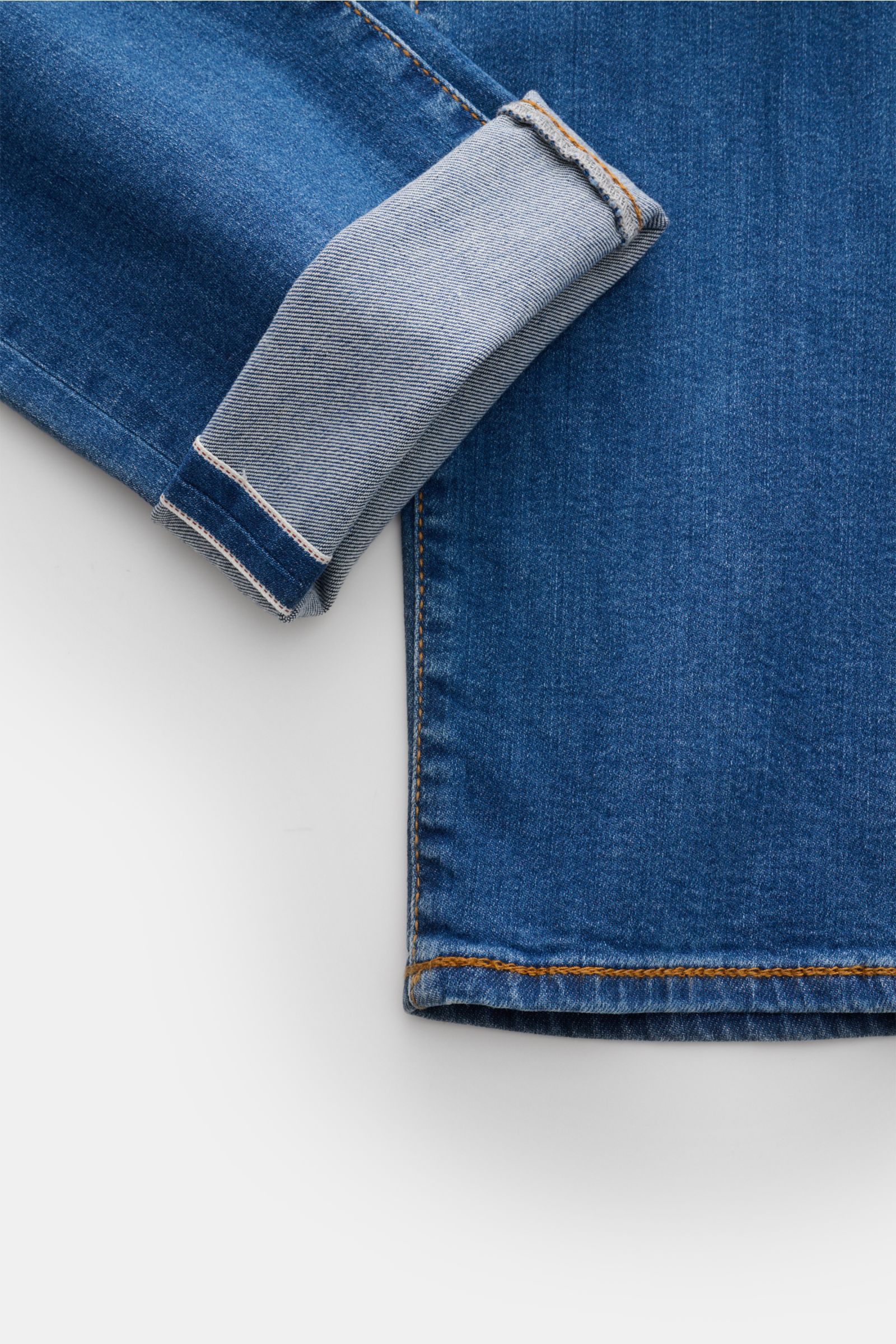 Nahaufnahme der Jacob Cohen Jeans 'Bard LTD' blau, schmal zulaufendes Bein mit umgeschlagenem Saum, dezente Used-Waschung, Selvedge-Denim.