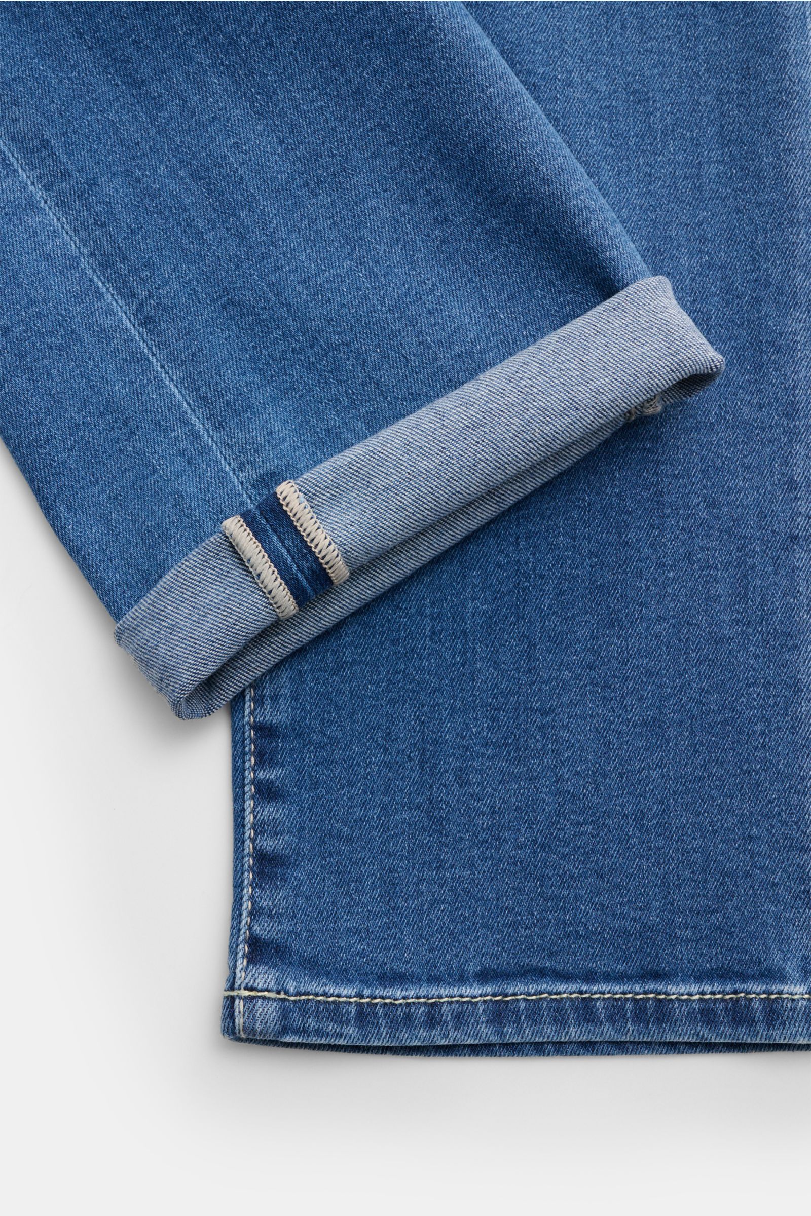 Close-up shot from above of the cuff and hem of Jacob Cohen Jeans 'Bard' rauchblau, showing soft cotton-Lyocell denim with elastic quality and subtle used wash. Setzen Sie auf modernen Luxus im Alltag: Die Premium-Jeans 'Bard' von JACOB COHEN kombiniert B