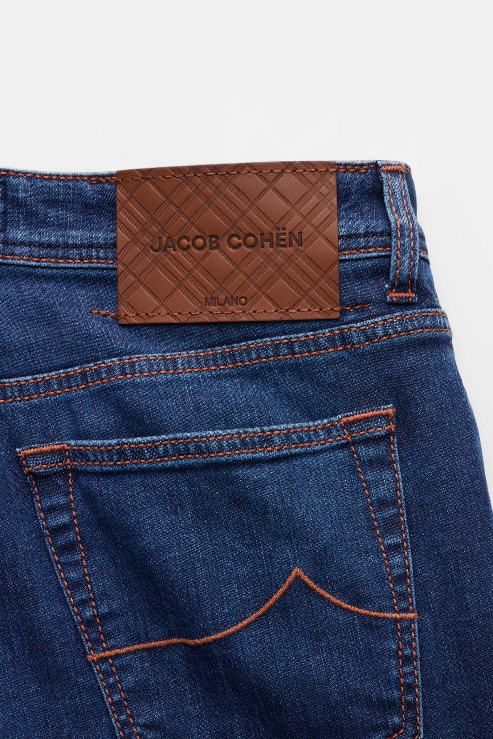 Close-up rear view of Jacob Cohen Jeans 'Bard' blau, showing blue elastic cotton denim with soft texture, slim fit, slight taper, button fly, five-pocket style, coin pocket with initial, back pockets with stitching, and brown leather patch with embossed b