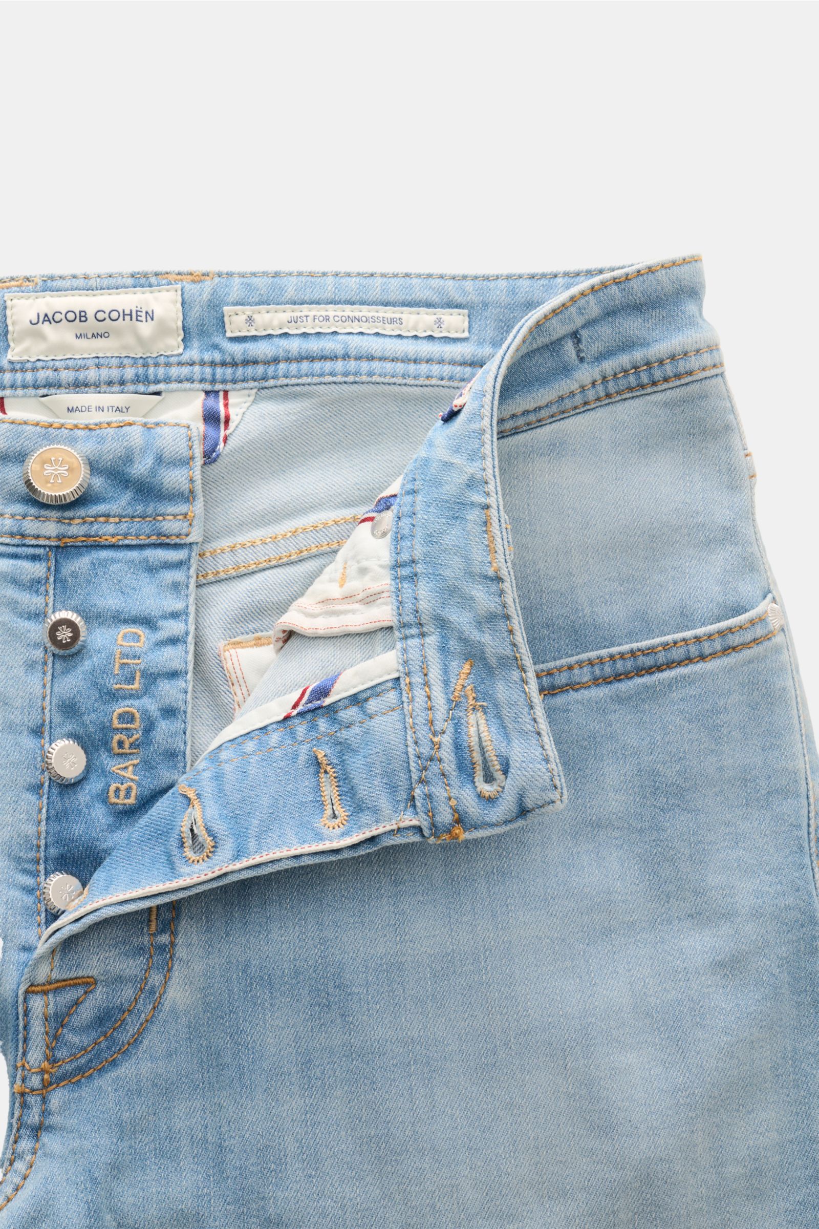 Front close-up of light blue Jacob Cohen Jeans 'Bard LTD' showing button fly, Selvedge details, and interior labels from a top-down perspective.

Moderne Lässigkeit kombiniert mit unverwechselbaren Details: das auffällige Kalbfell-Patch ist das Markenz