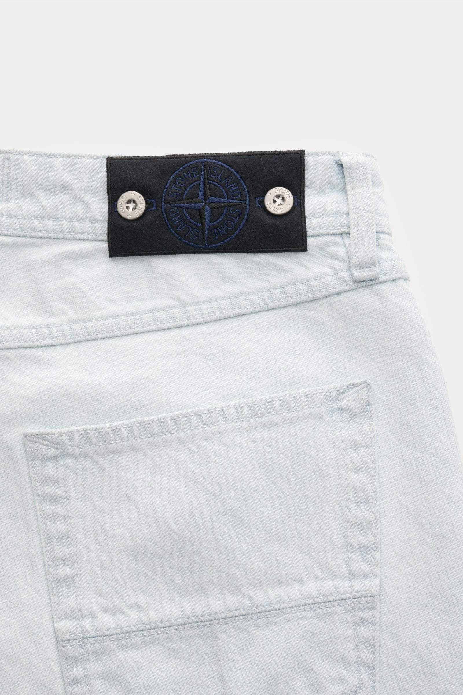 Stone Island Jeans 'Bleach' hellblau, Rückansicht mit hellblauem Denim, geradem Schnitt, Five-Pocket-Stil und Kompass-Badge am Bund.
