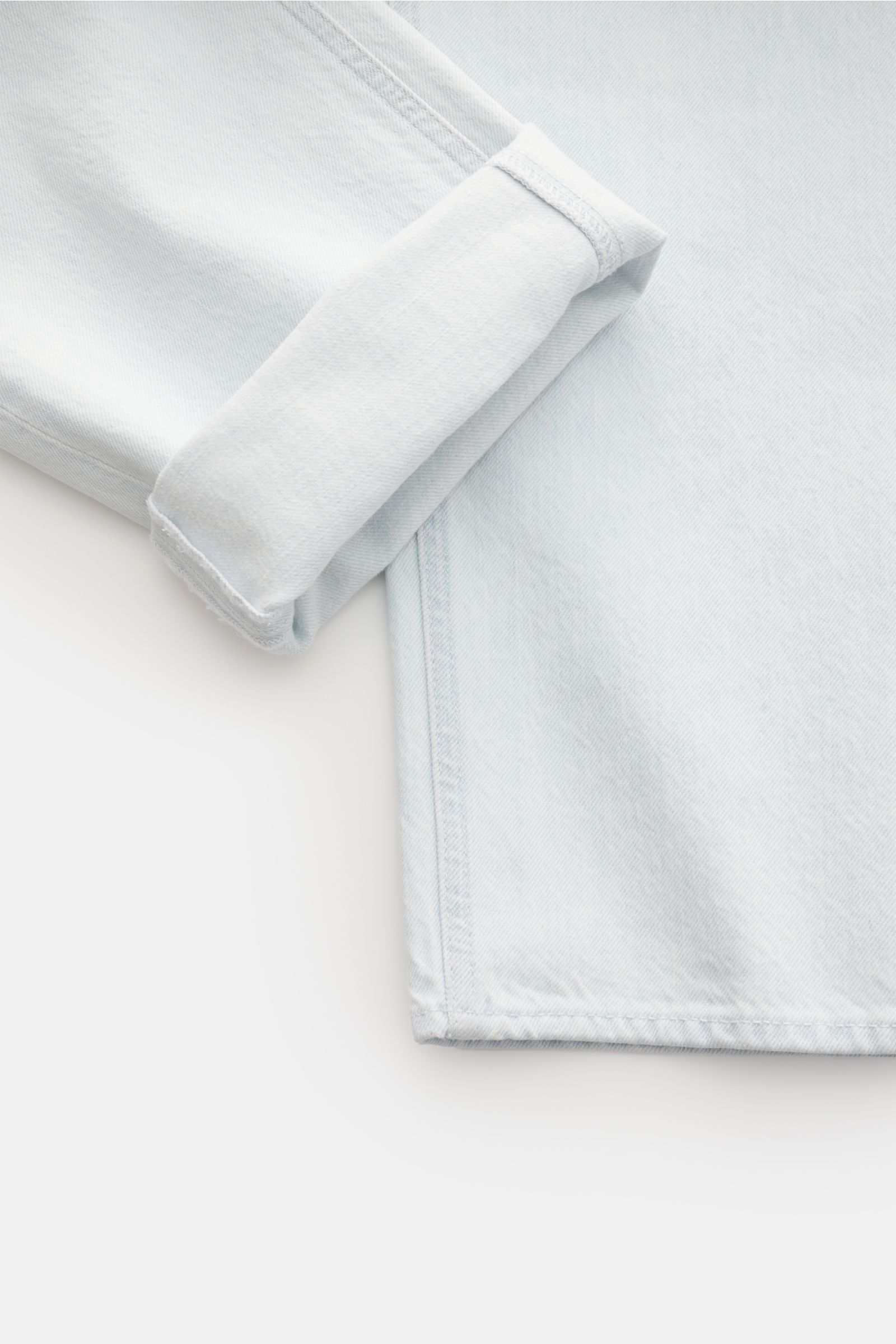 Stone Island Jeans 'Bleach' hellblau, Detailaufnahme der umgeschlagenen Beinöffnung, gerader Schnitt, reiner Baumwoll-Denim.