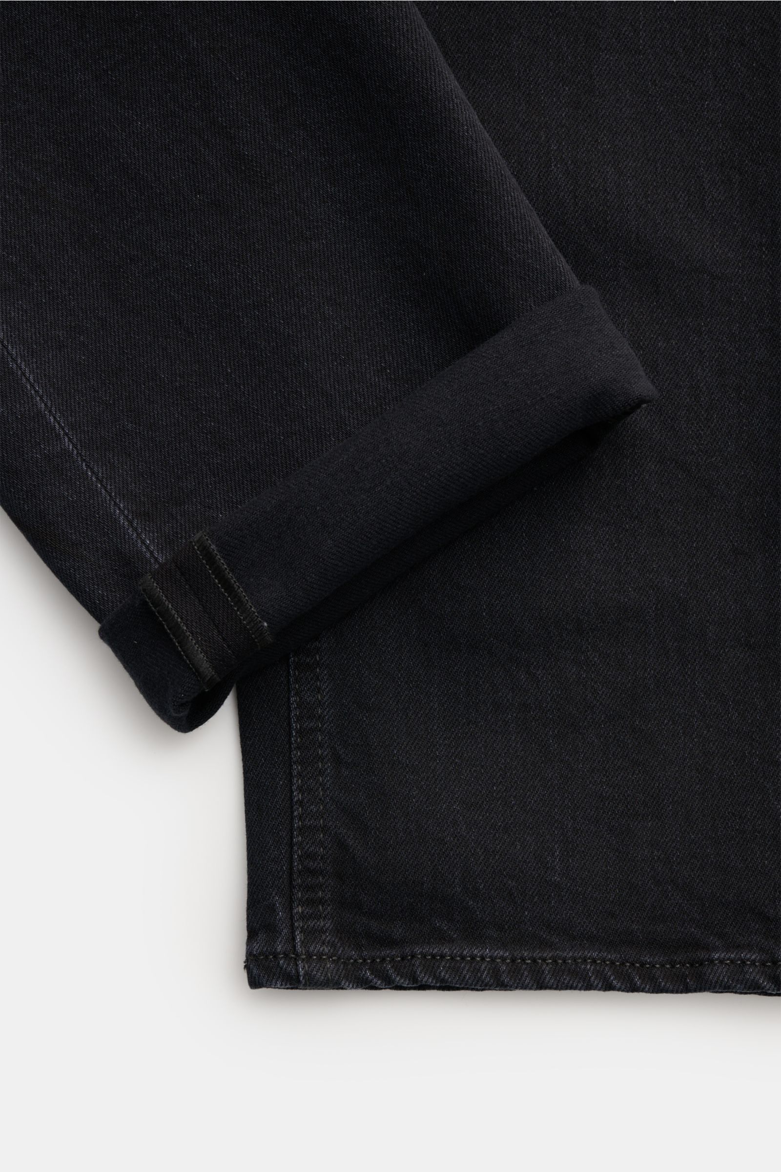 Stone Island Jeans 'Stretch Black Denim - Rinsed' schwarz, Slim Fit, schmal zulaufend, Detailansicht des umgeschlagenen Saums aus Baumwolle mit Kompass-Badge.