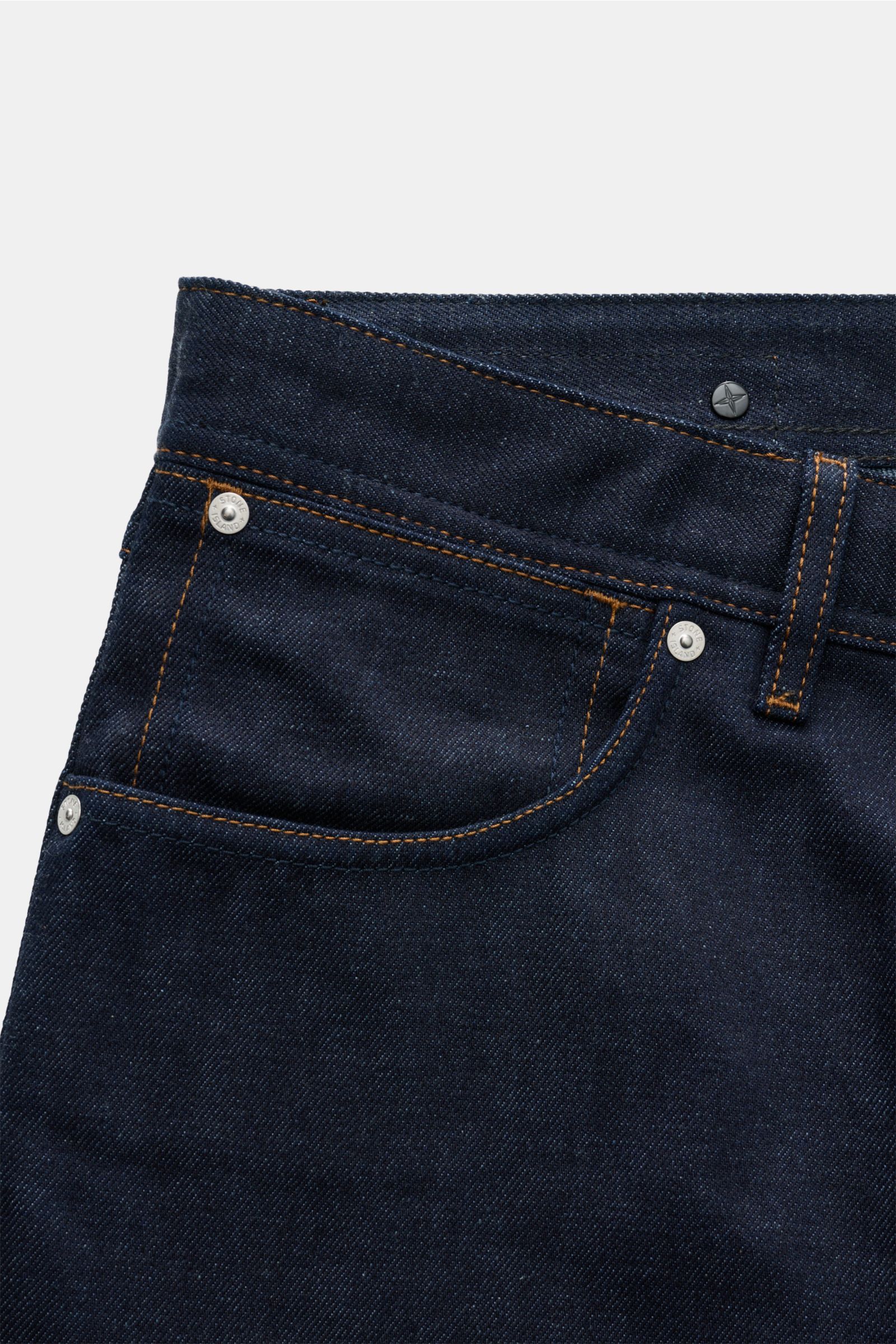 Stone Island Jeans 'Selvedge Indigo Denim - Raw' navy, close-up front view showing raw denim fabric, straight fit, button fly, five-pocket style, and compass badge.