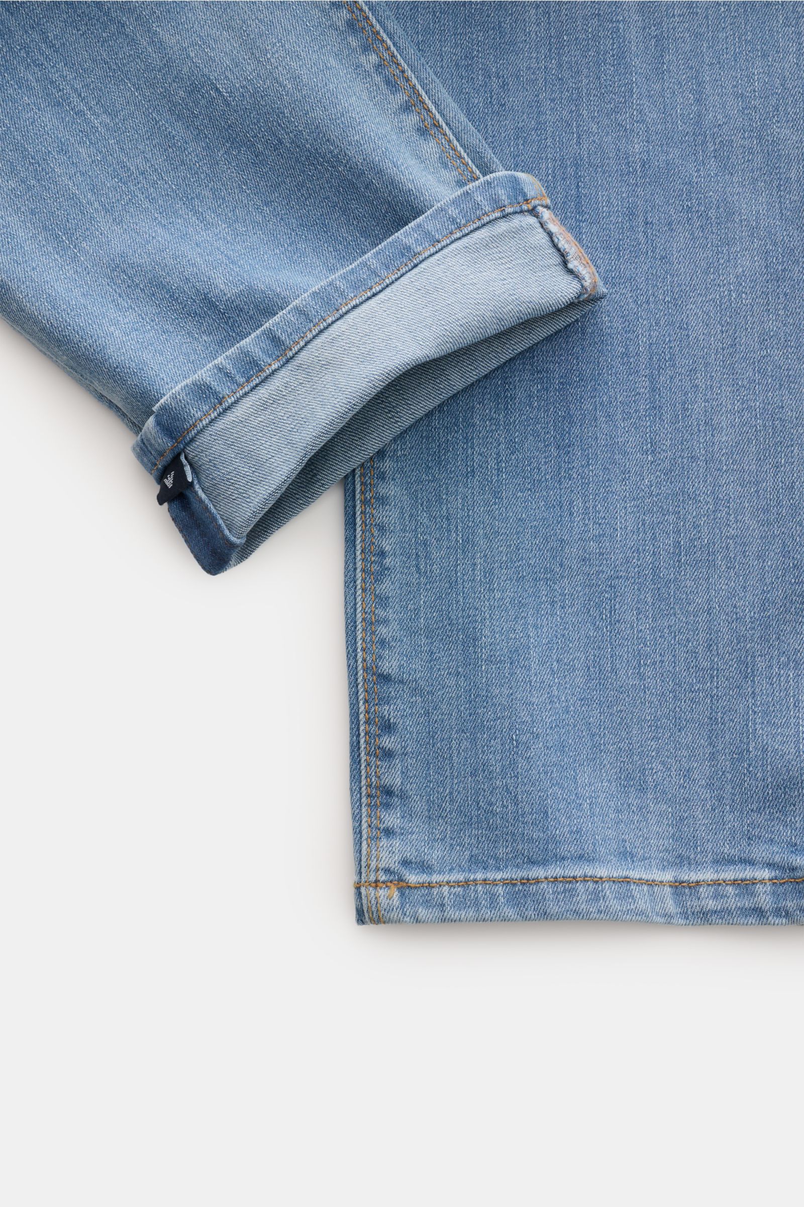 Emporio Armani Jeans rauchblau shown from a flat lay top-down perspective, focusing on the cuff and hem details. Komfort trifft Stil: Die Jeans von EMPORIO ARMANI überzeugt durch angenehmen Tragekomfort und zeitlose Ästhetik für moderne Casual-Looks.